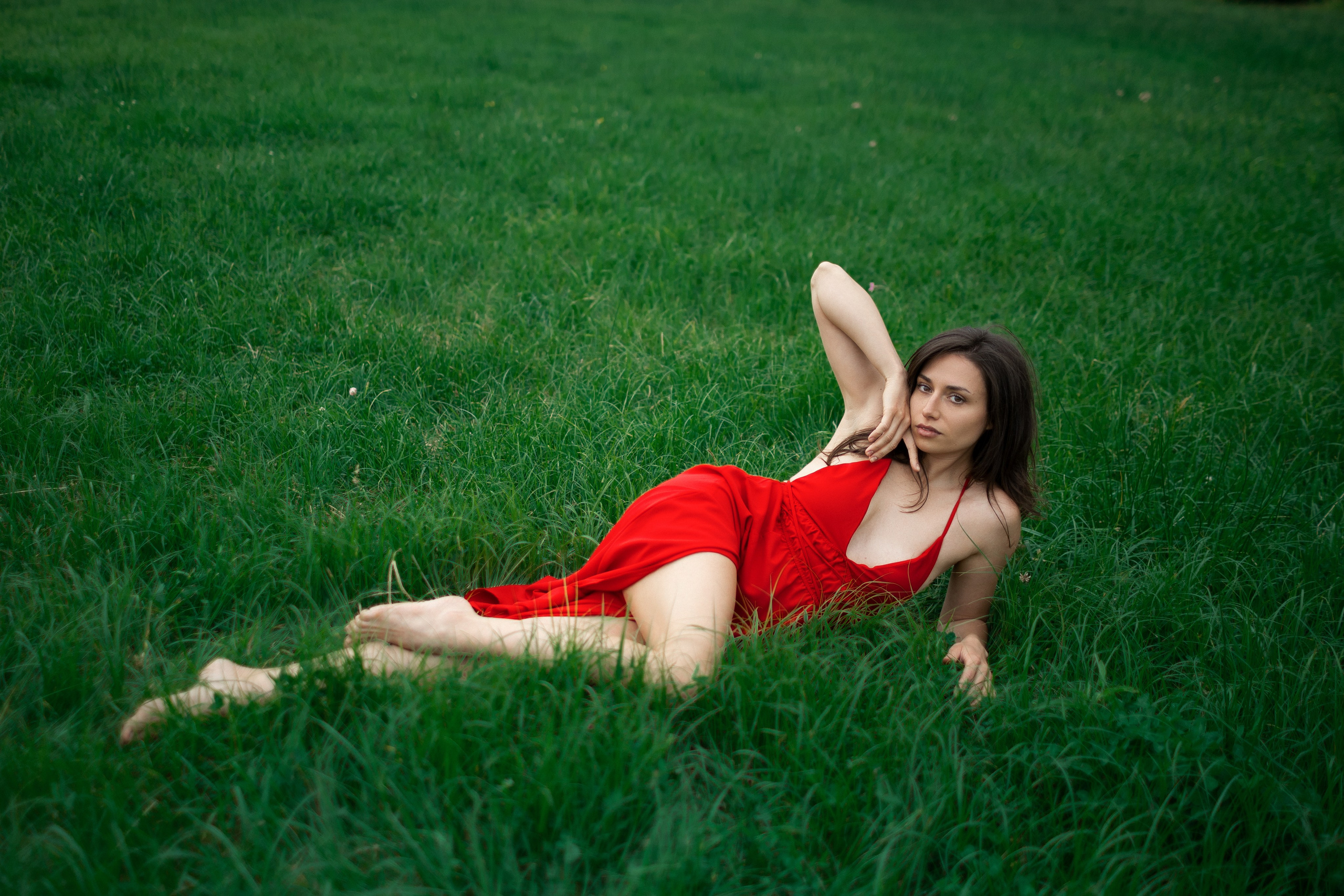 Frau liegend in hoher Wiese in einer femininen Pose