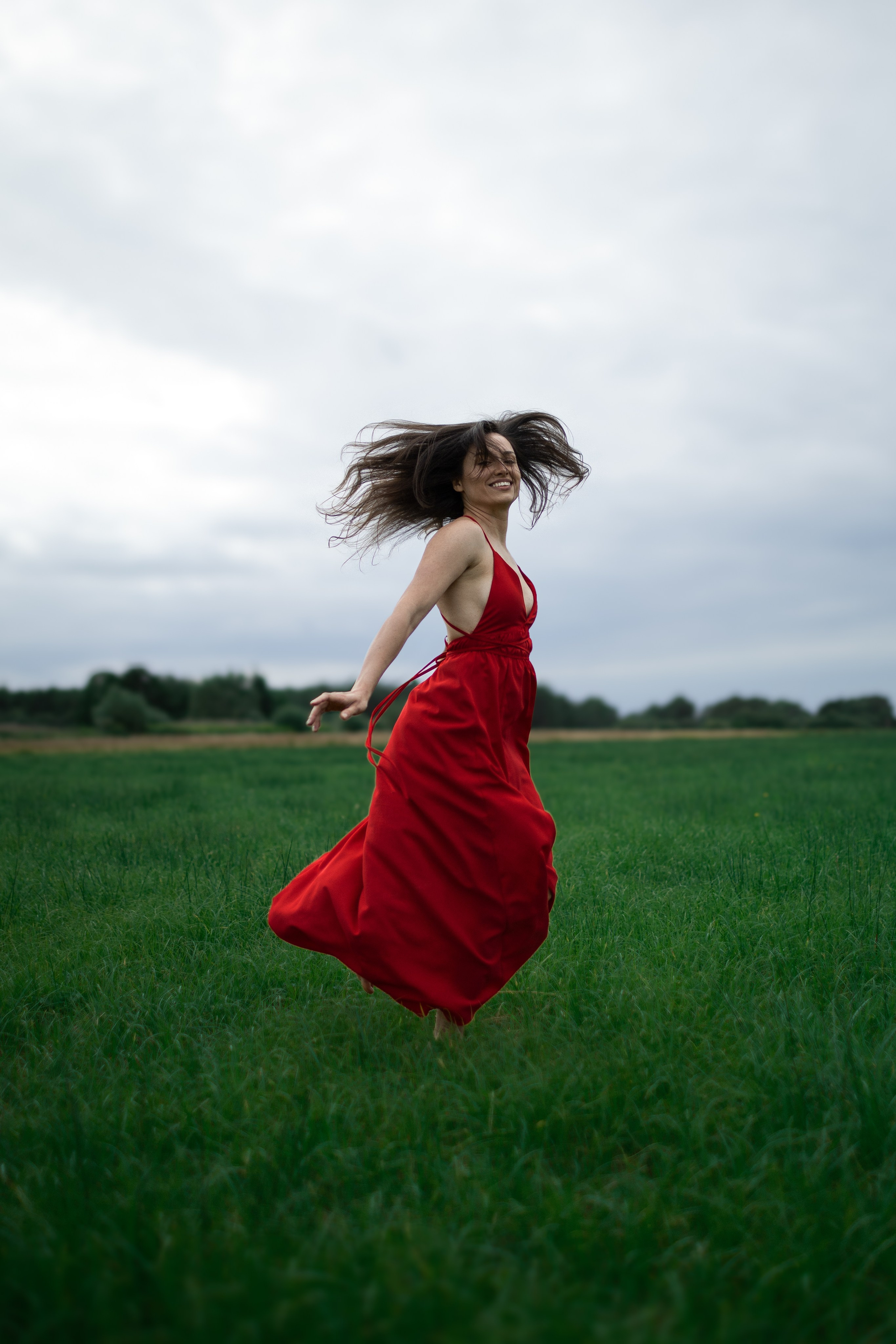 Frau springt in hoher Wiese bei einem kreativen Fotoshooting