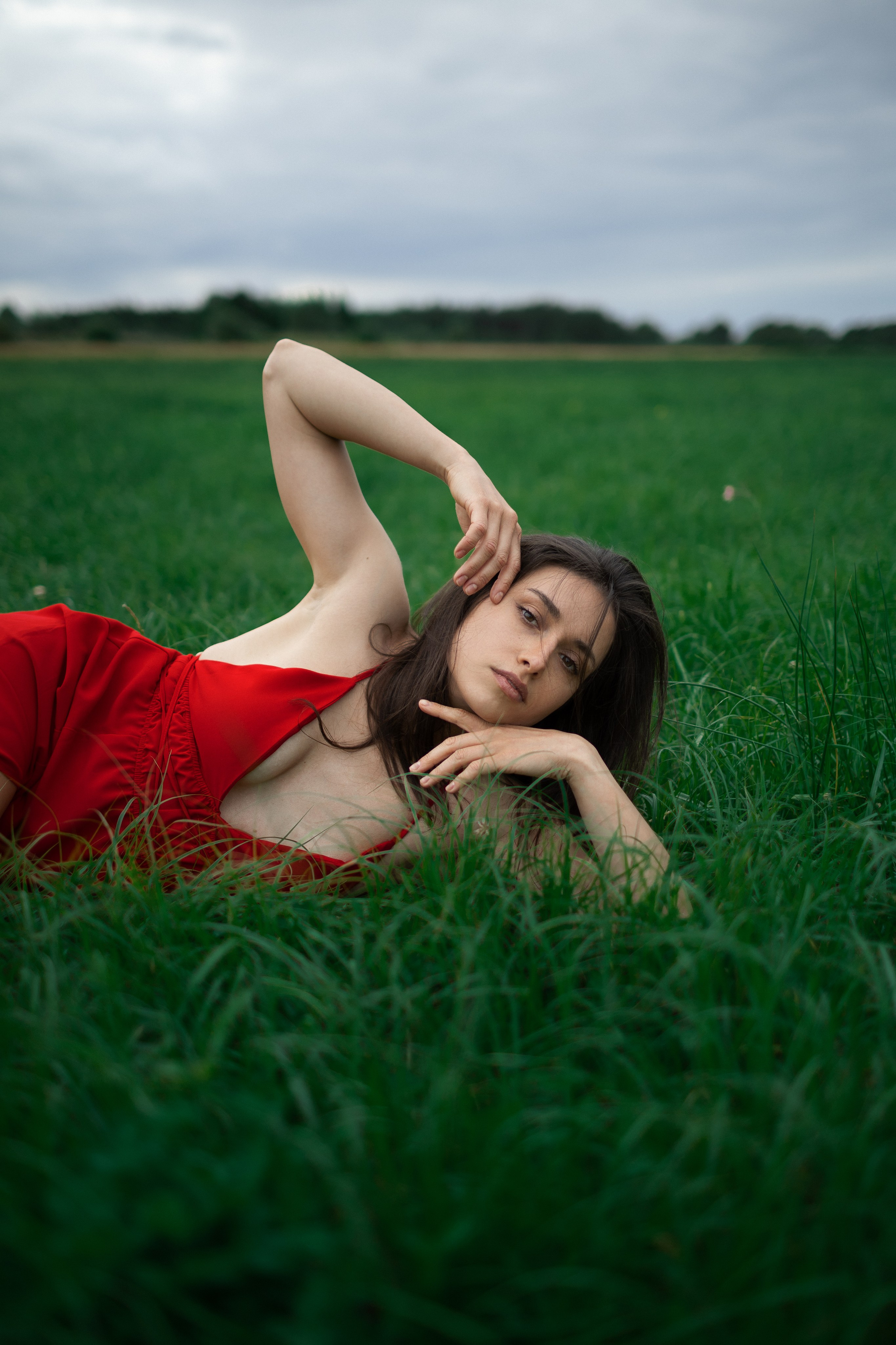 Nahportrait einer Frau liegend im Gras bei natürlichem Licht