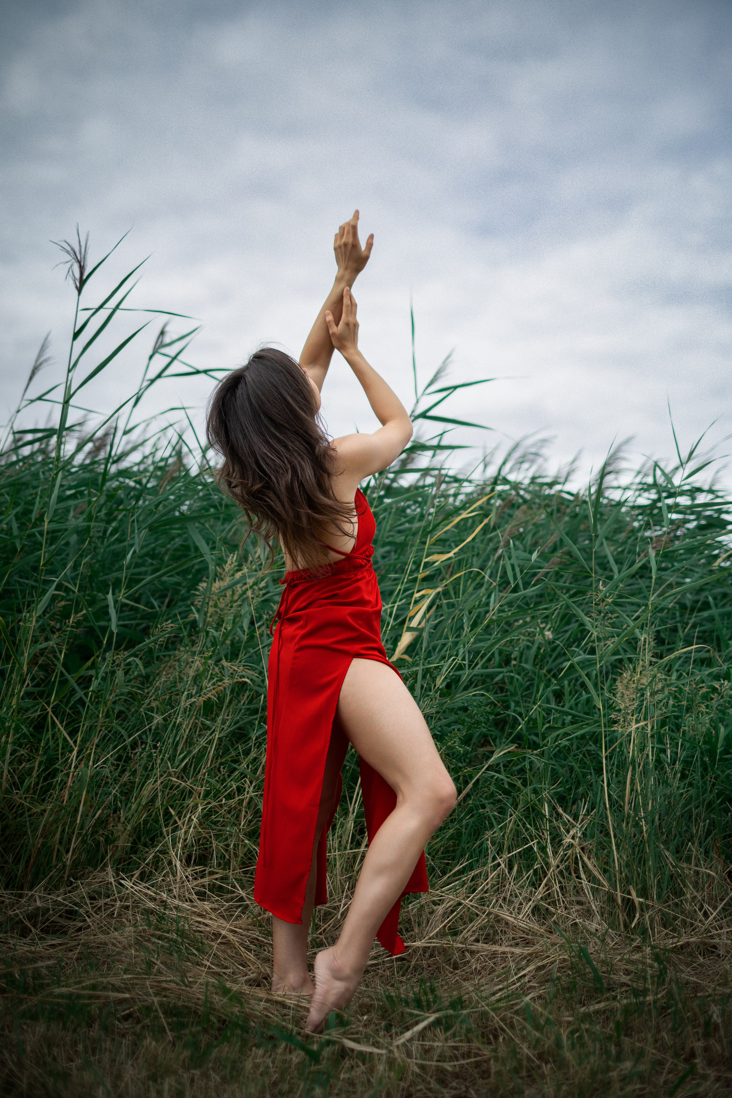 Frau im Wind auf einer Wiese bei einem kreativen Outdoor-Fotoshooting