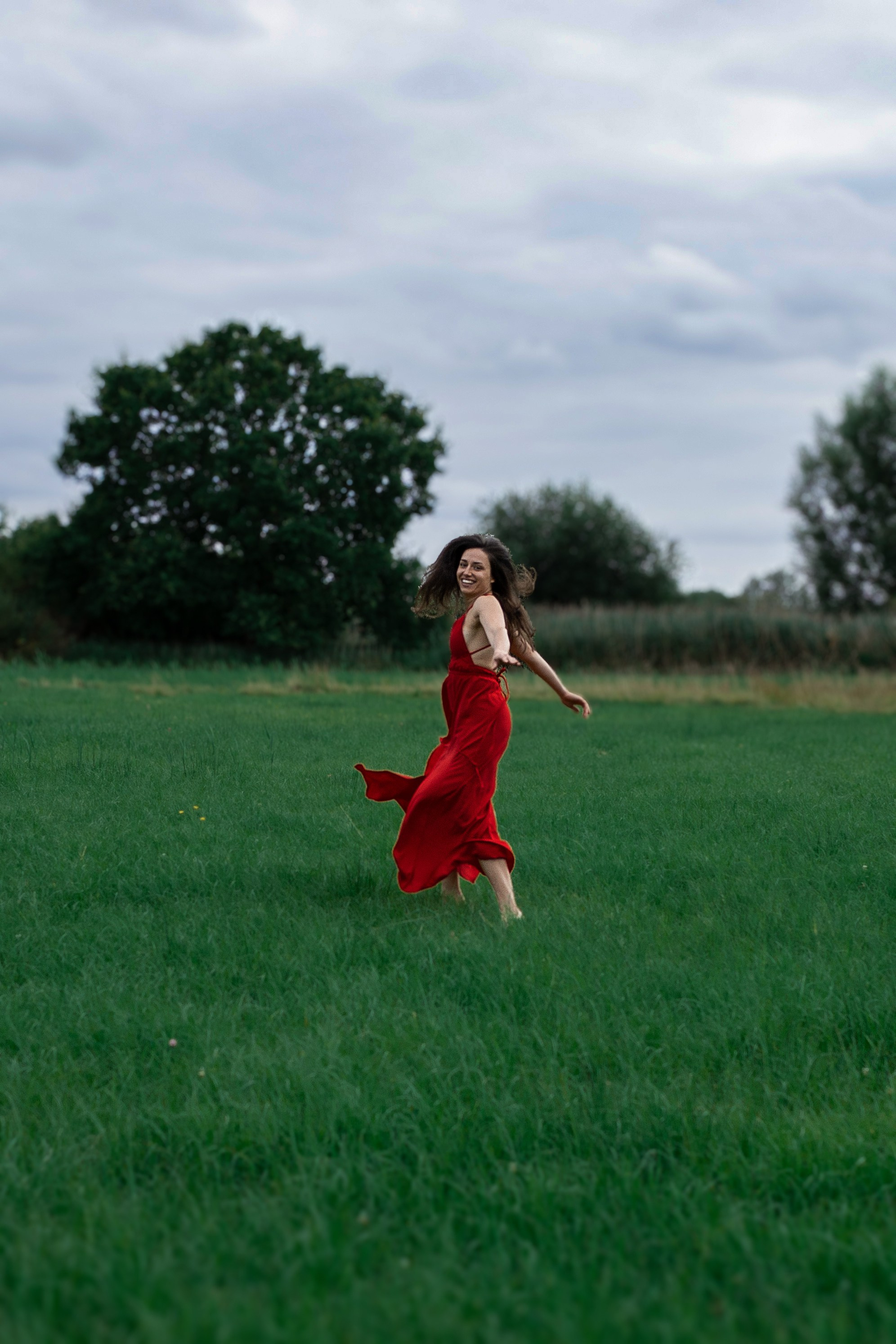 Frau läuft durch hohe Gräser bei einem Outdoor-Fotoshooting