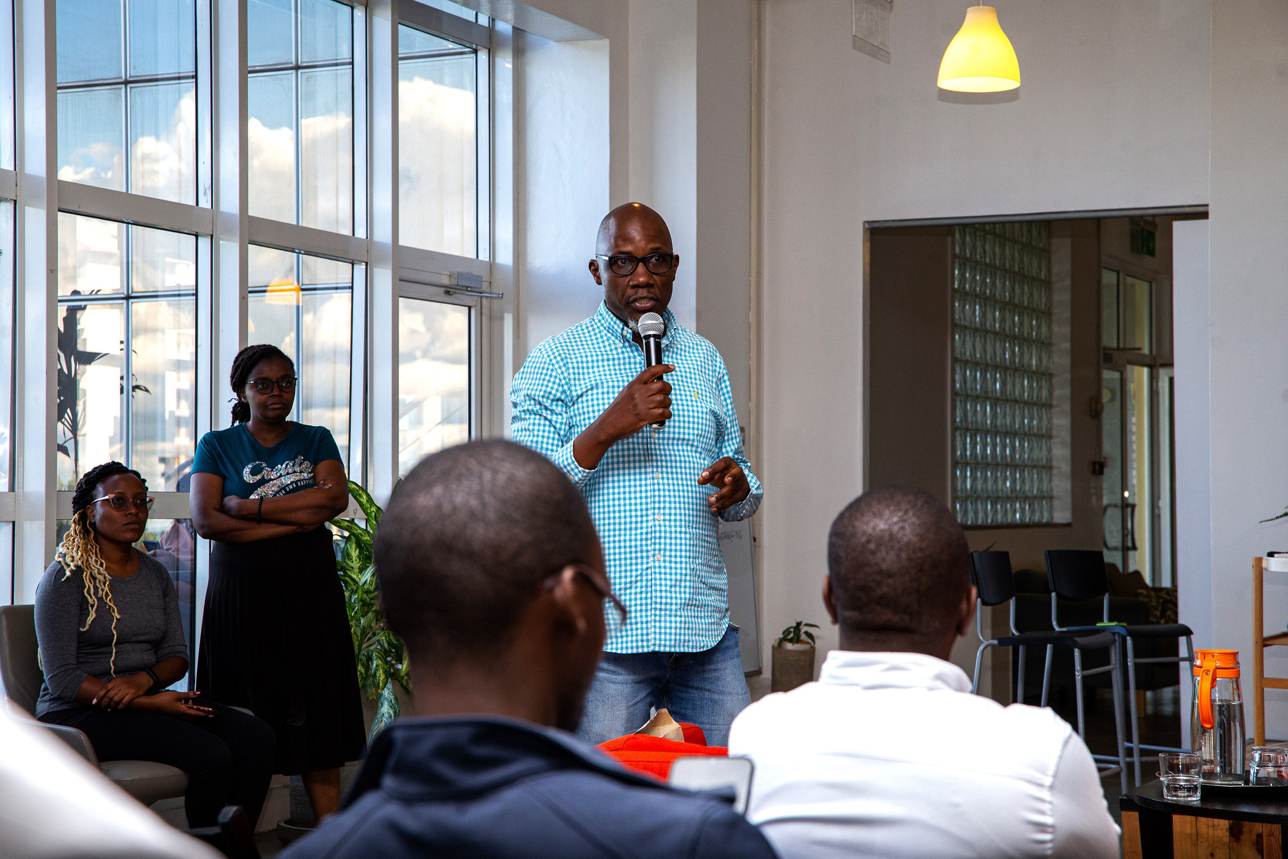 A point-of-view photo of attendees focusing on a gentleman giving a speech, at a corporate event in Nairobi.