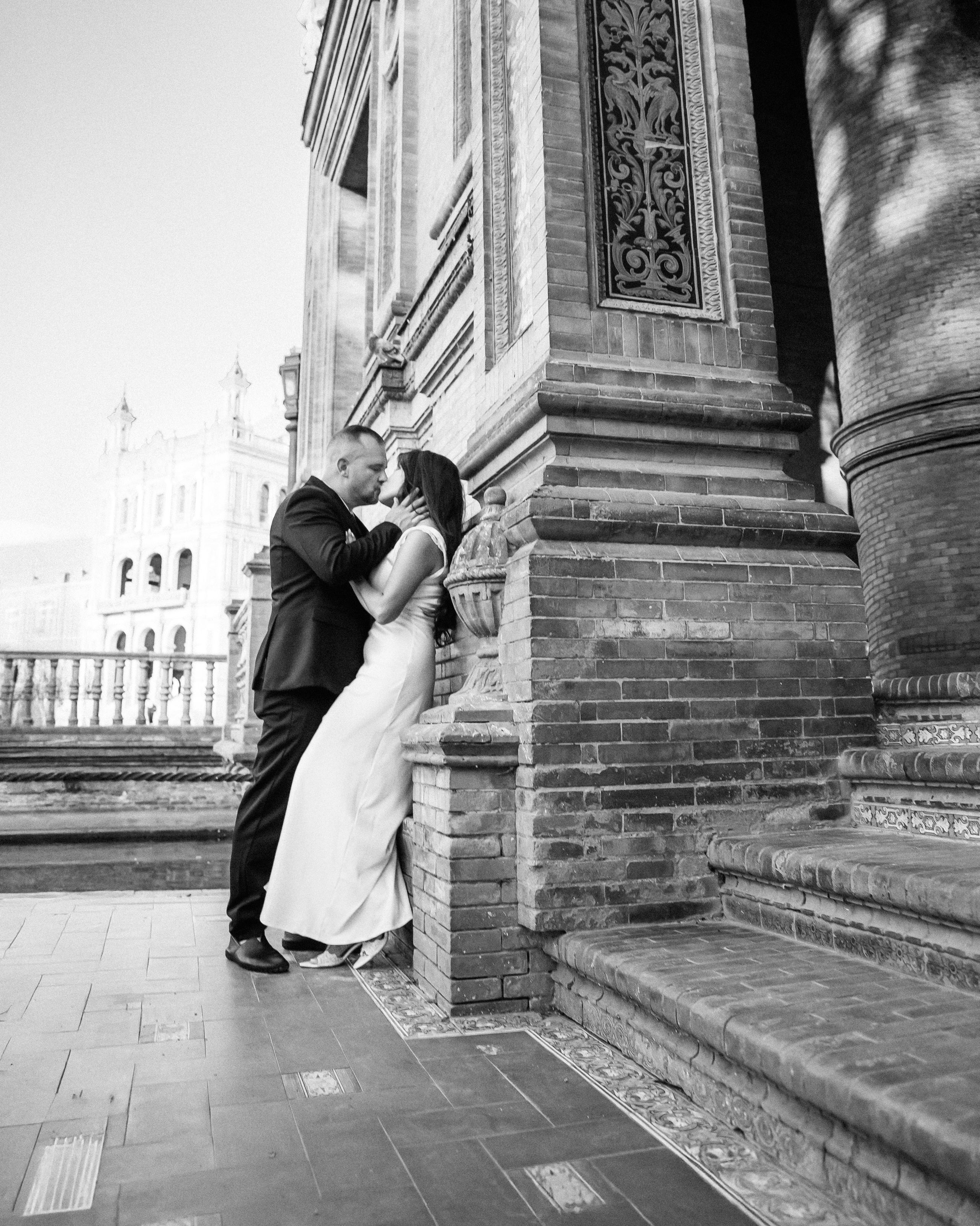 Black and white photo of the couple kissing on the grand staircase at Plaza de España, Sevilla. Timeless moment from their romantic elopement in southern Spain.