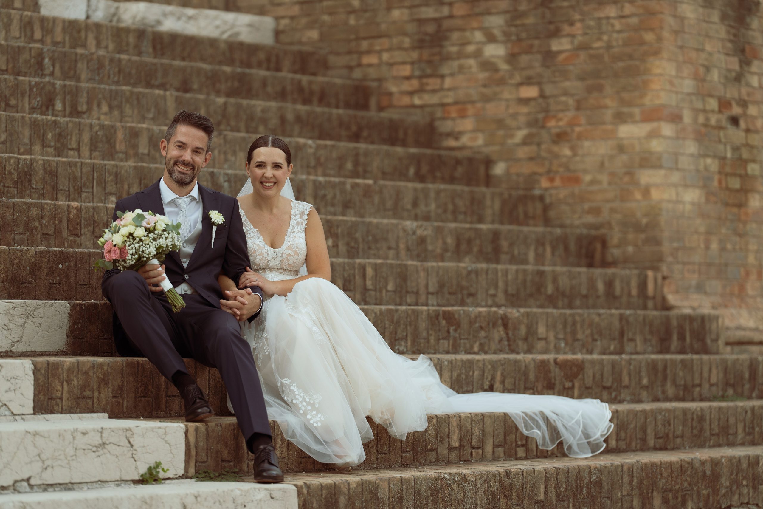 Sposo in abito blu attende la sposa durante il matrimonio all’aperto.