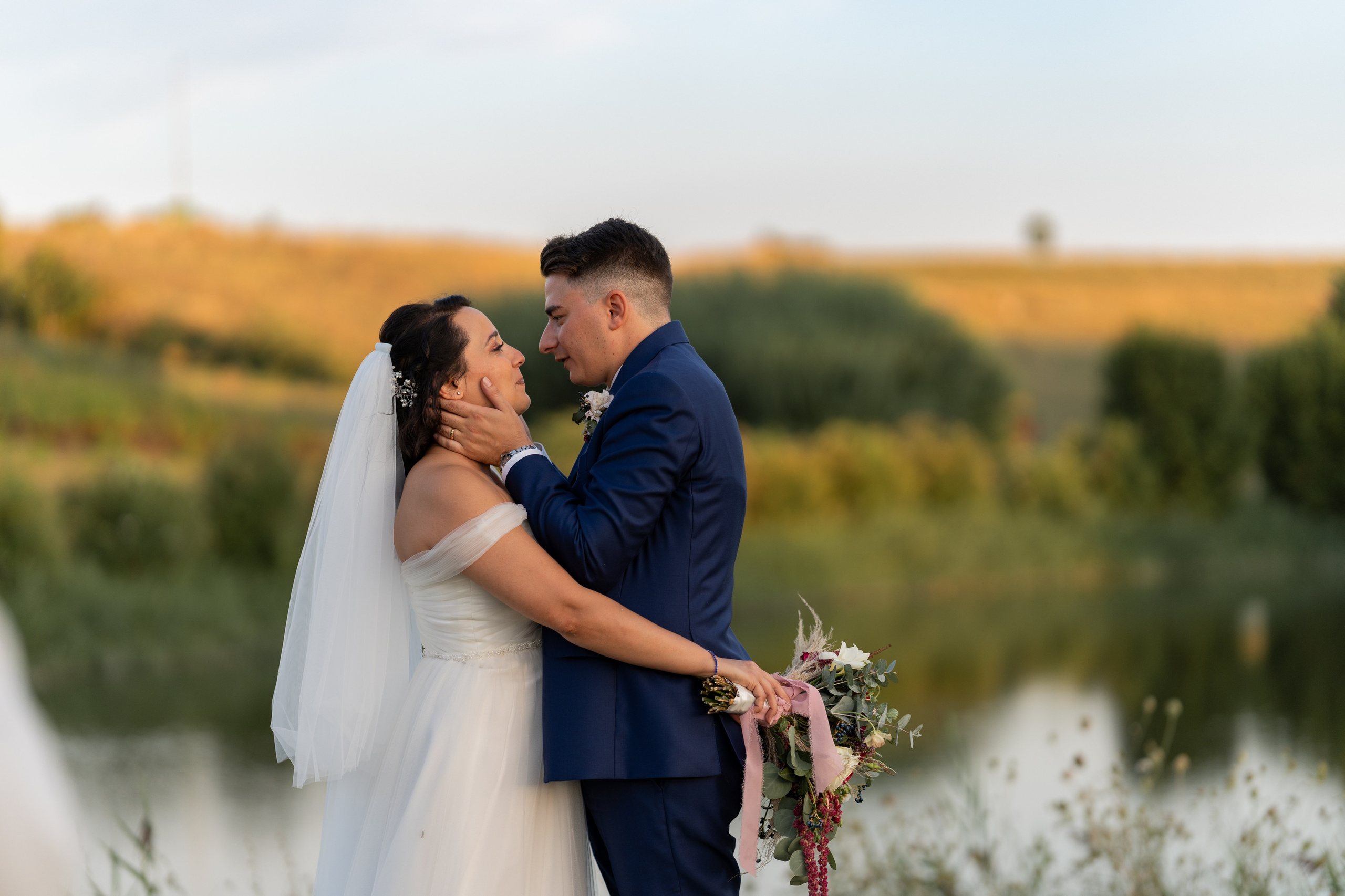 Bride and groom share a quiet moment together beneath the open sky.
