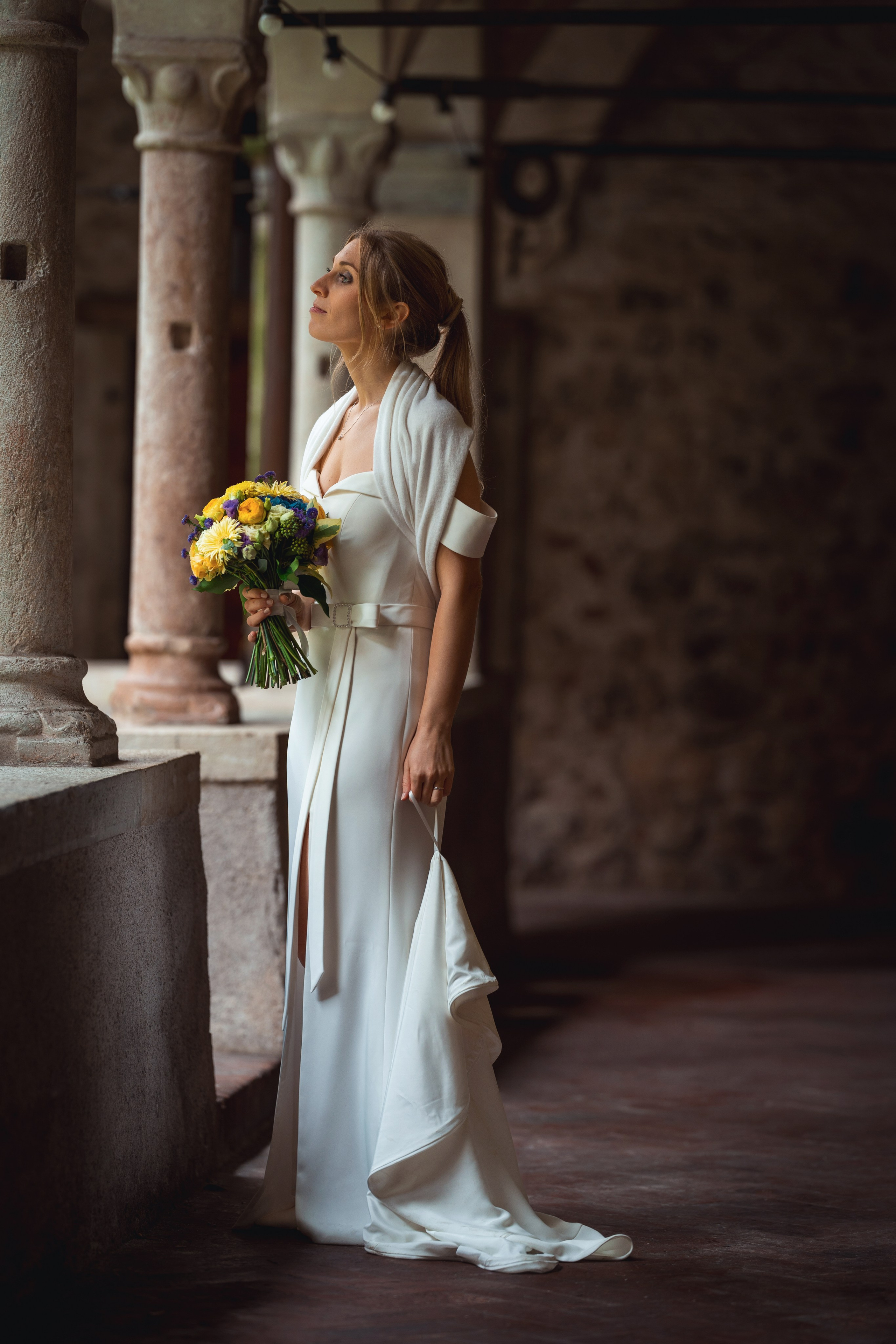 Bride and groom share a romantic moment beneath the wedding flowers.