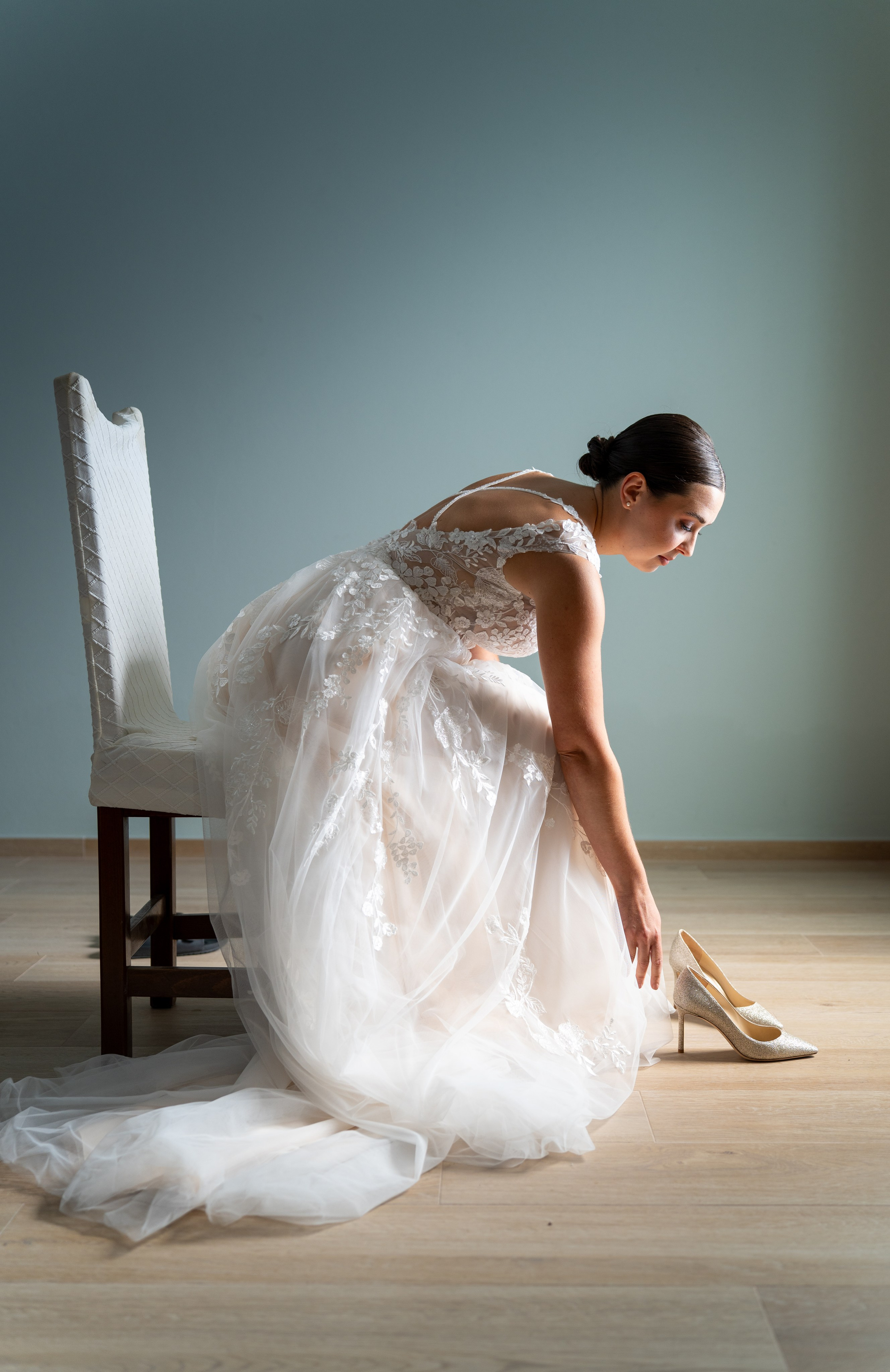 La sposa posa da sola all’aperto, tra il verde e la luce naturale.