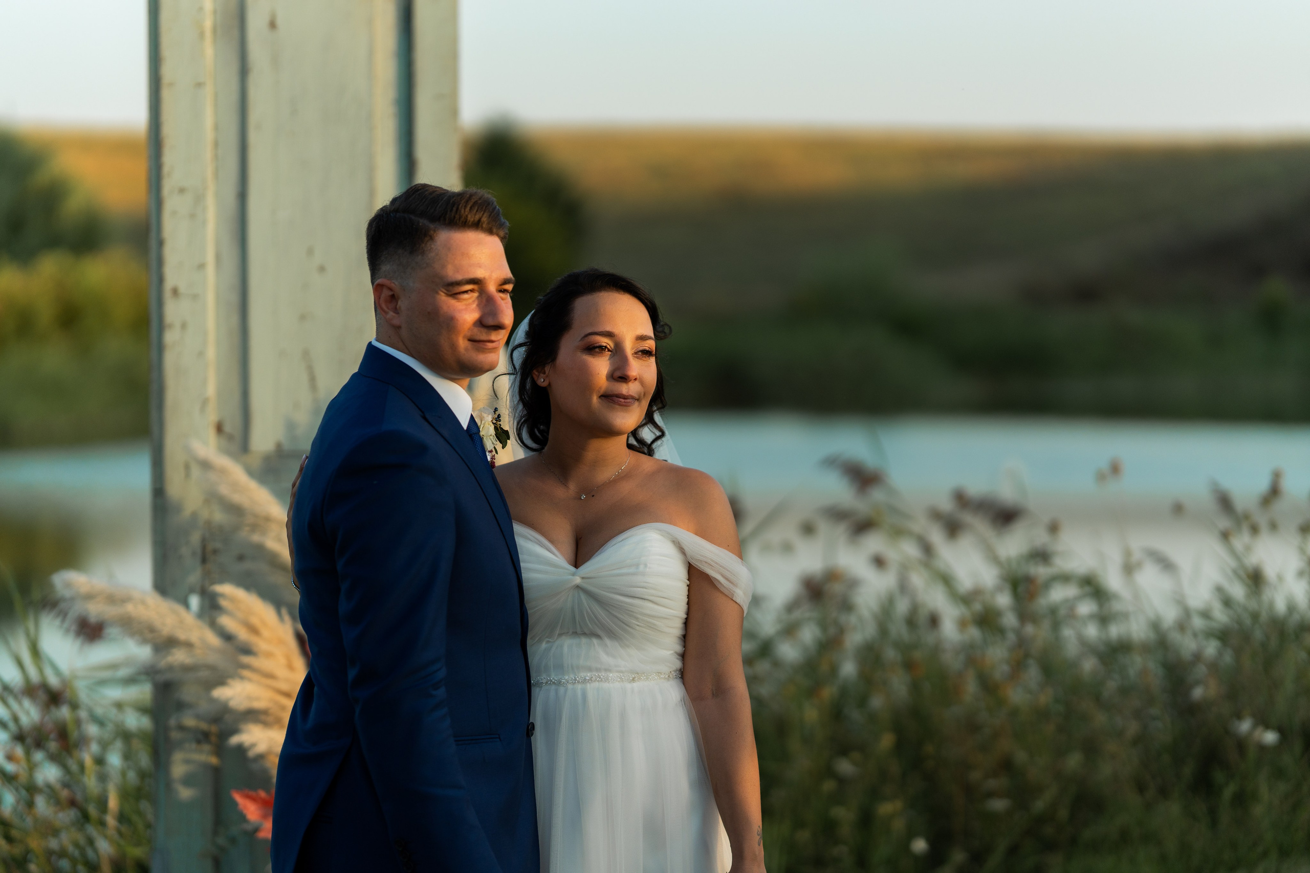 Gli sposi si scambiano un bacio all’aperto nel verde, durante il loro matrimonio.