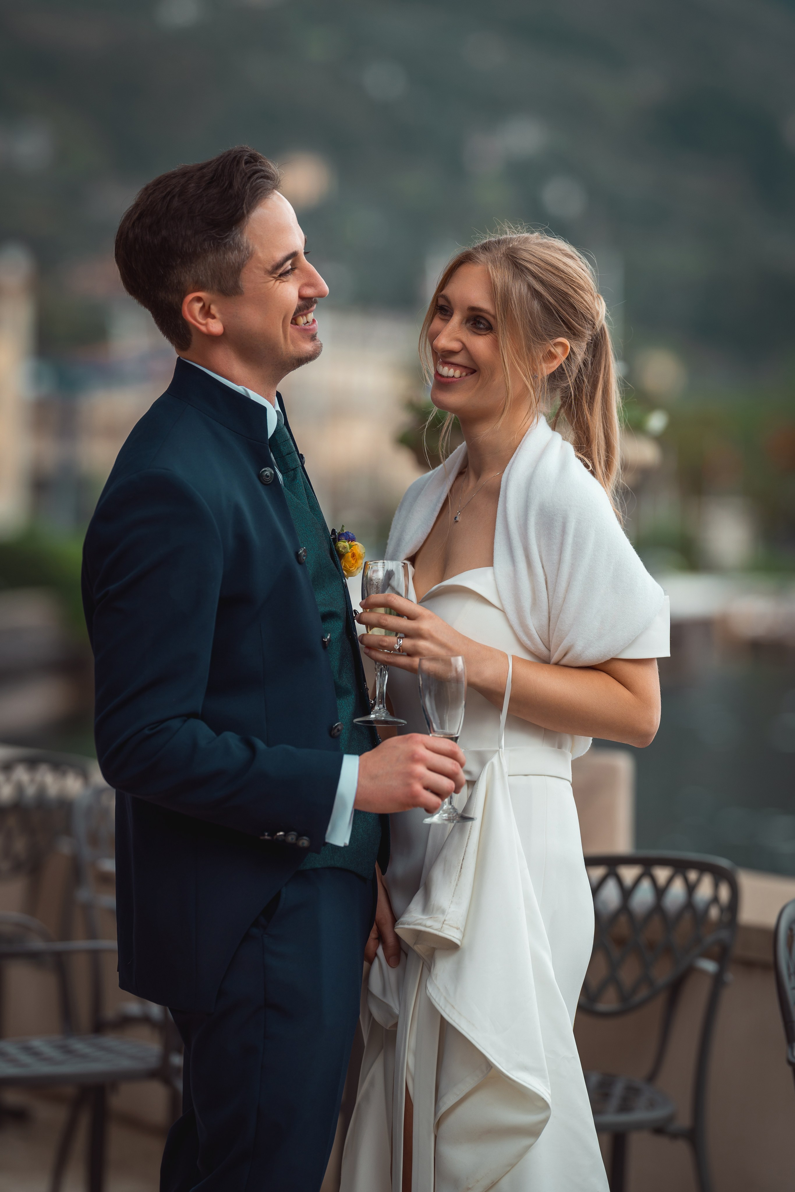 Sposi sorridenti si guardano negli occhi durante il ritratto di coppia.