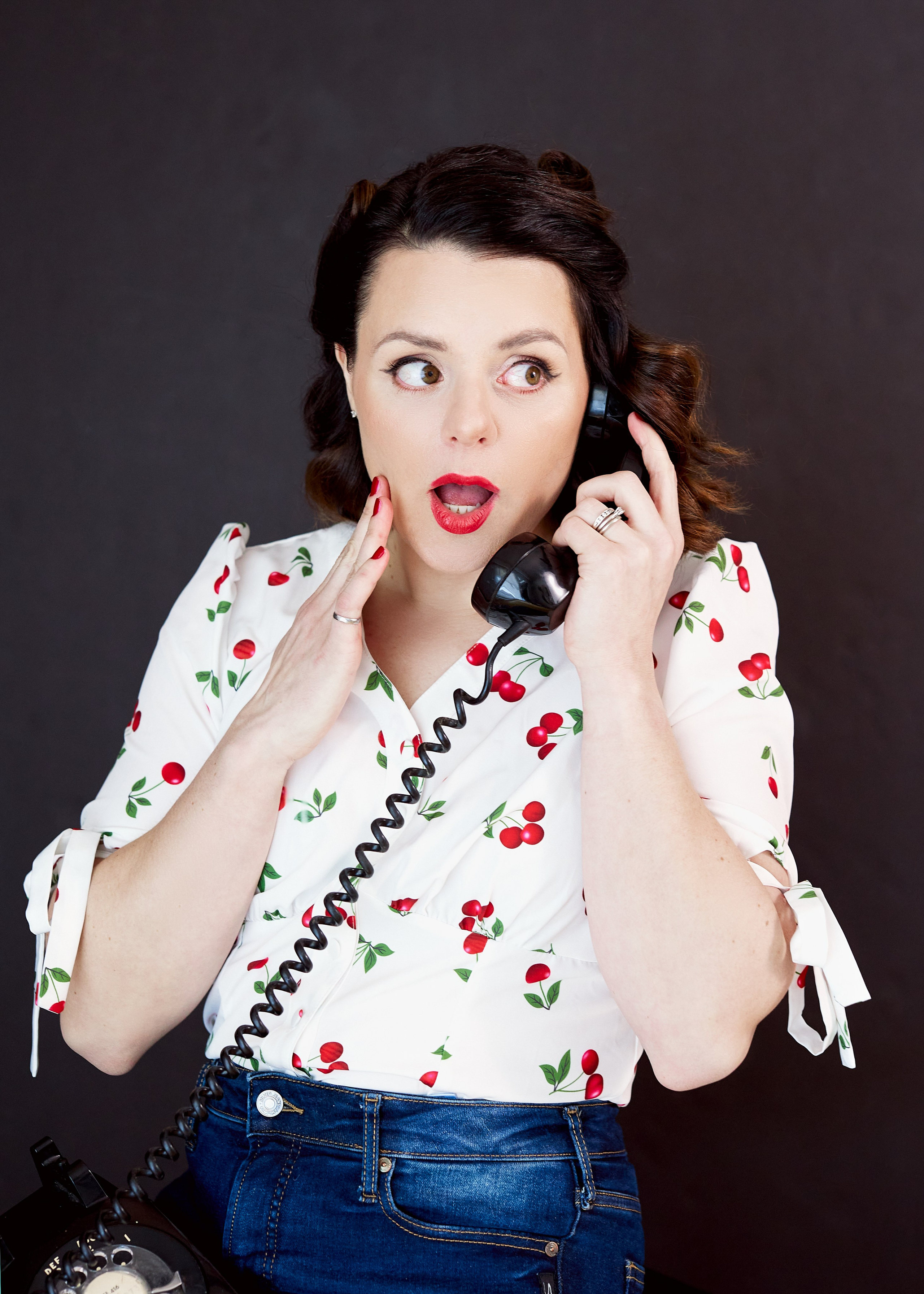 headshot of woman talking on vintage telephone 