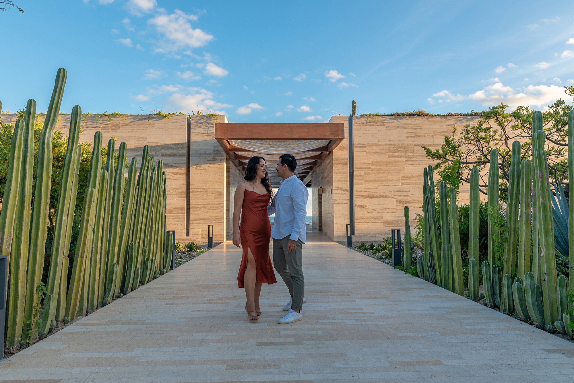 Couple photoshoot in Los Cabos – romantic walk along mosaic path with cactus walls and ocean view