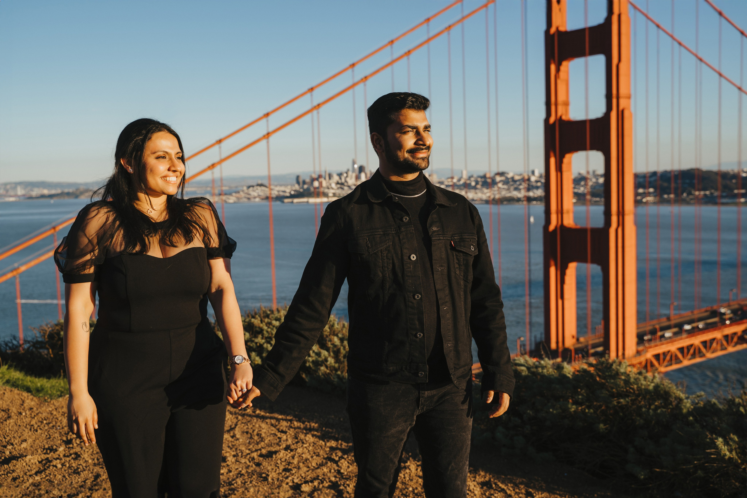 Proposal.  Overlooking the golden San Franisco Bridge sunset with a couple. Photographer Video. 