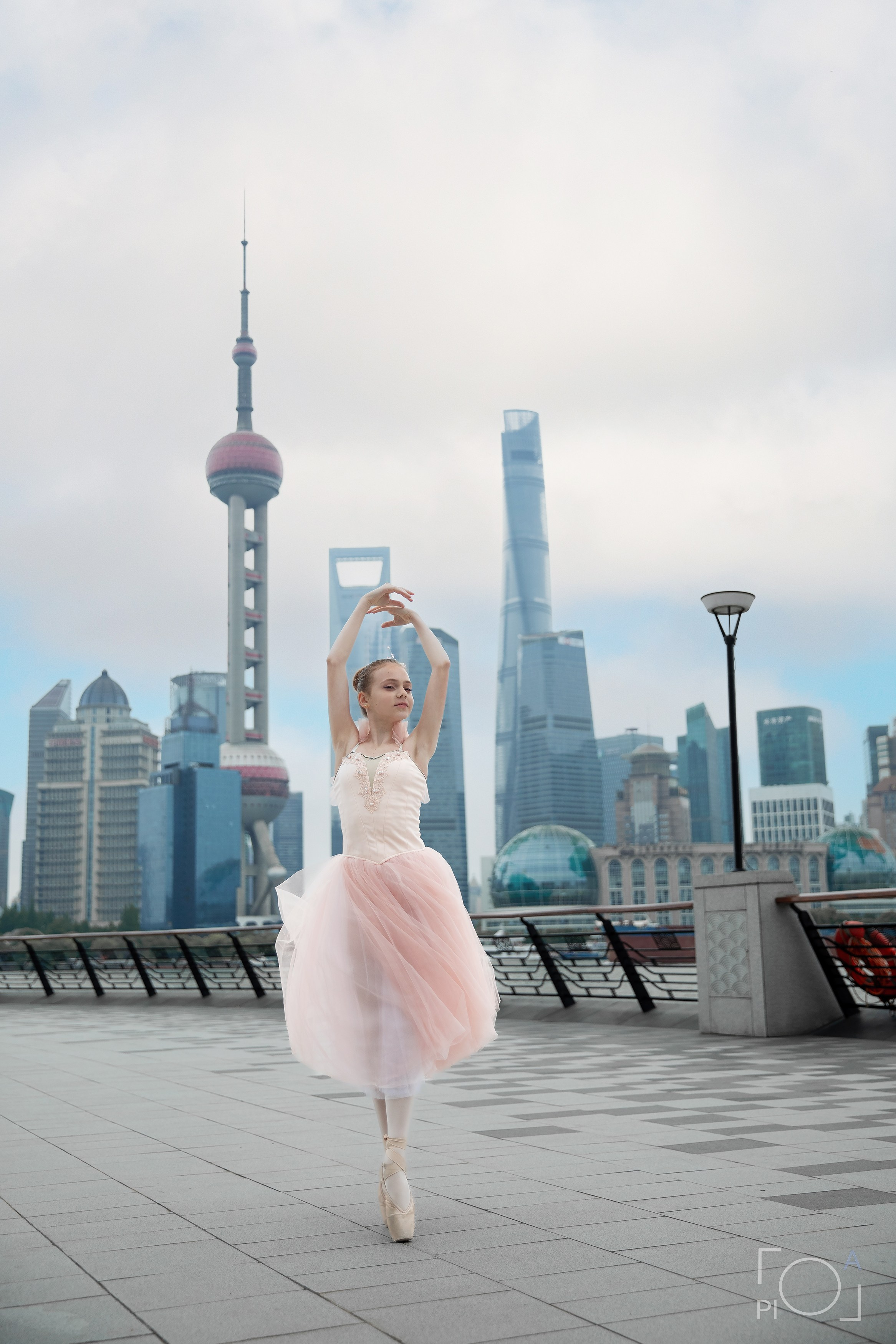 Фотосессия в Шанхае для девочки 11 лет. Маленькая балерина в розовом платье с пышной длинной пачкой, танцует на набережной в Шанхае с видом на Lujiazui
