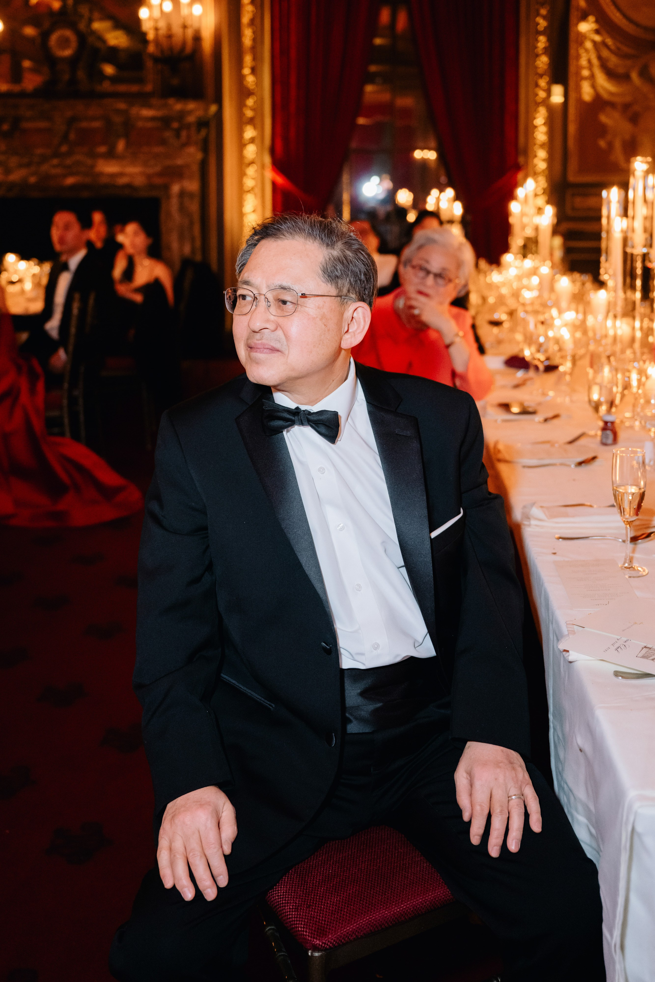 a man in a tuxed suit sitting at a table
