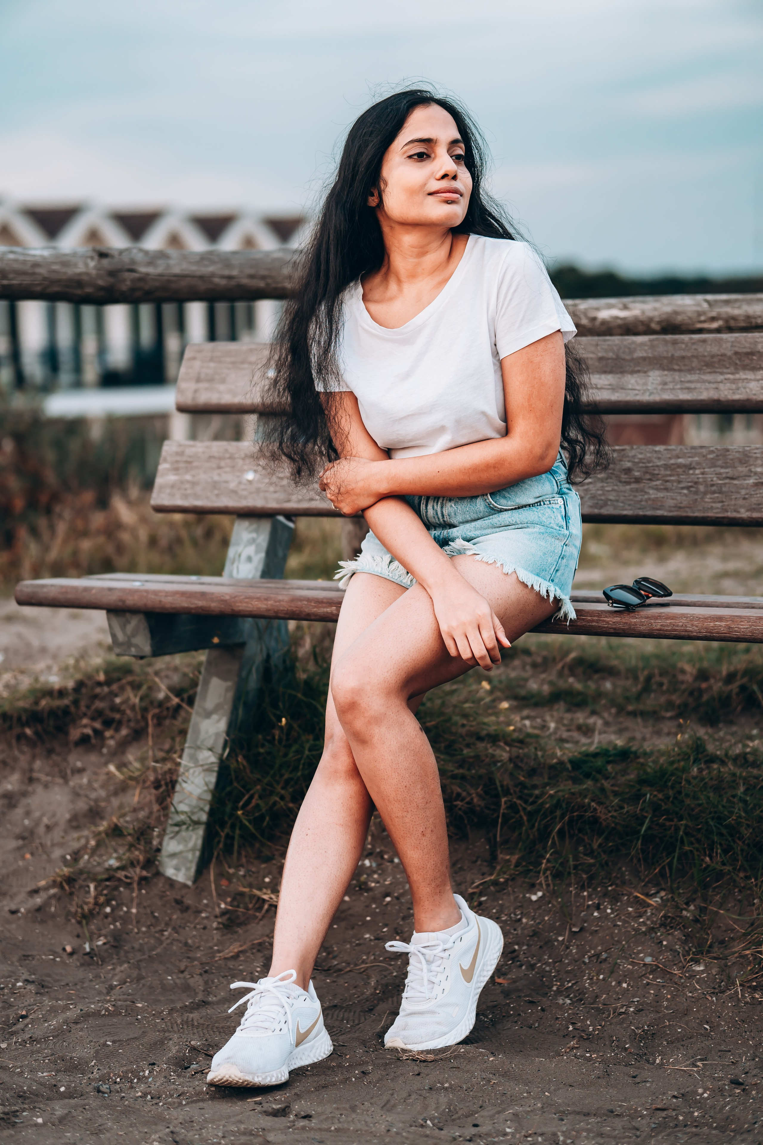 Woman sitting on a bench next to the beach
