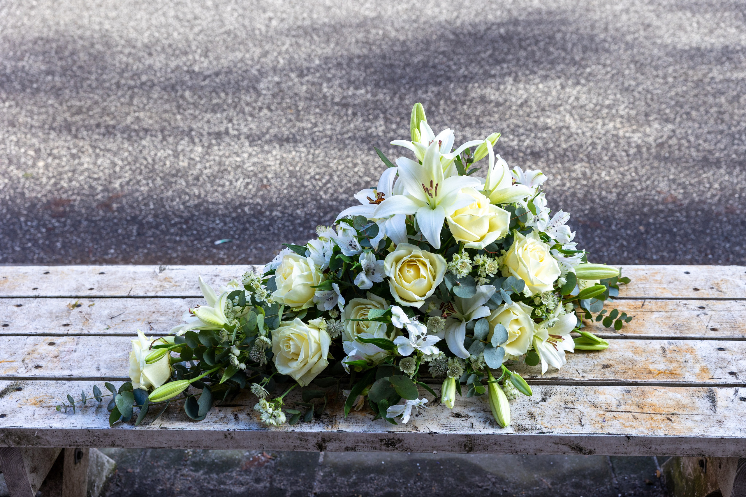 Smuk båredekoration opbygget i oasis med højde og længde på blomsterstilkene. Båredekorationen er elegant kombineret i de creme-hvide nuancer. Et smukt farvel, som lyser kirkegulvet op til alle årstider.