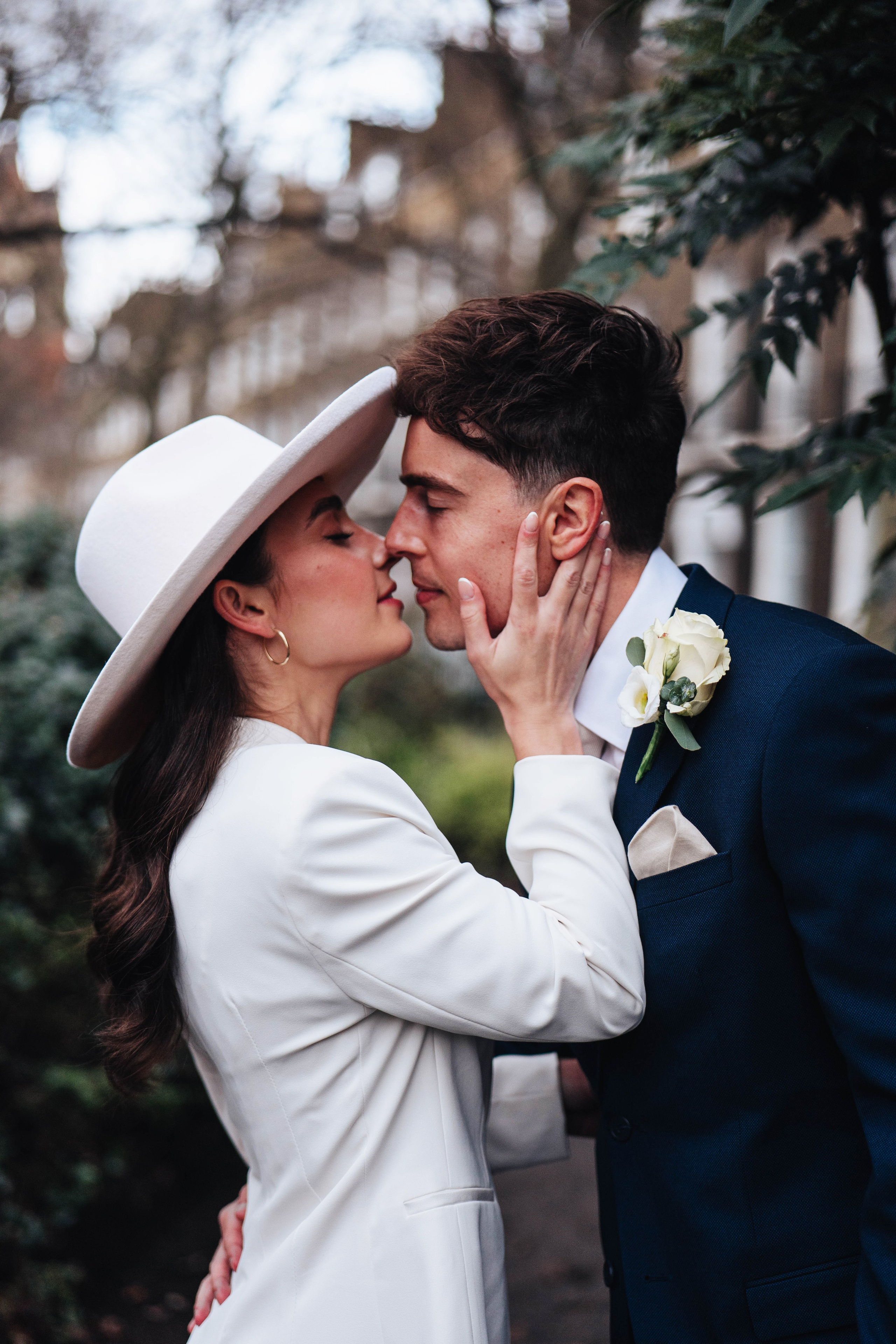 Stylish wedding in Islington, white women costume and white hat, kissing