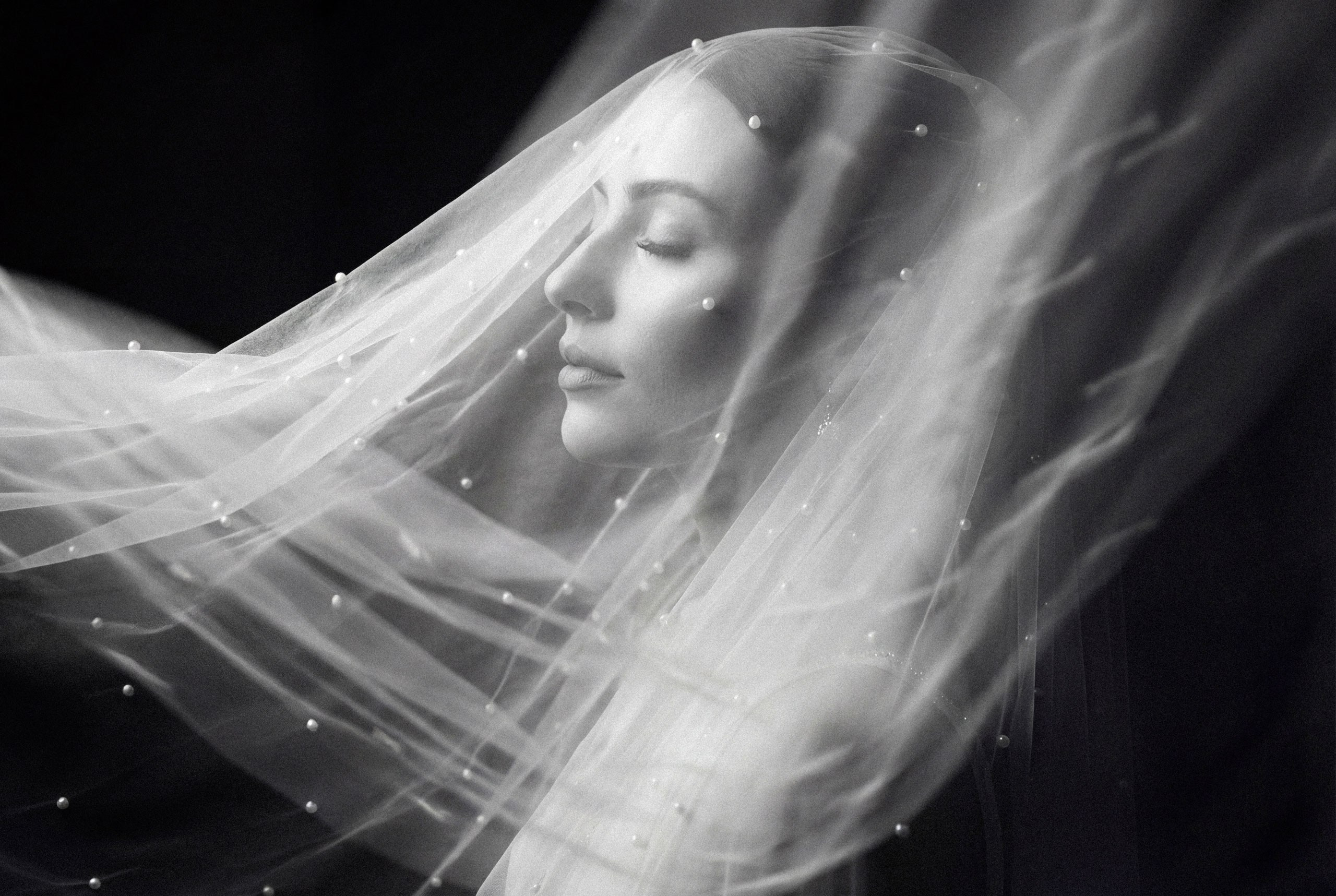 Ethereal portrait of the bride covered with wedding veil with pearls