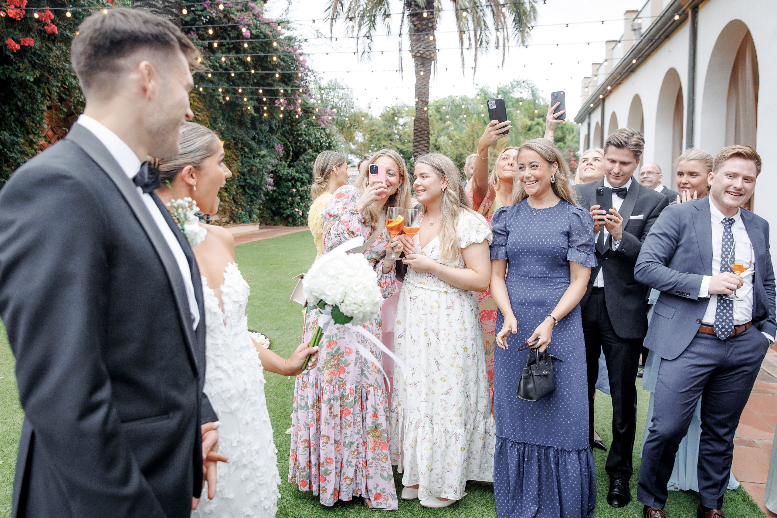 Candid shot of wedding guests laughing and chatting during the ceremony in Barcelona, capturing genuine emotions.