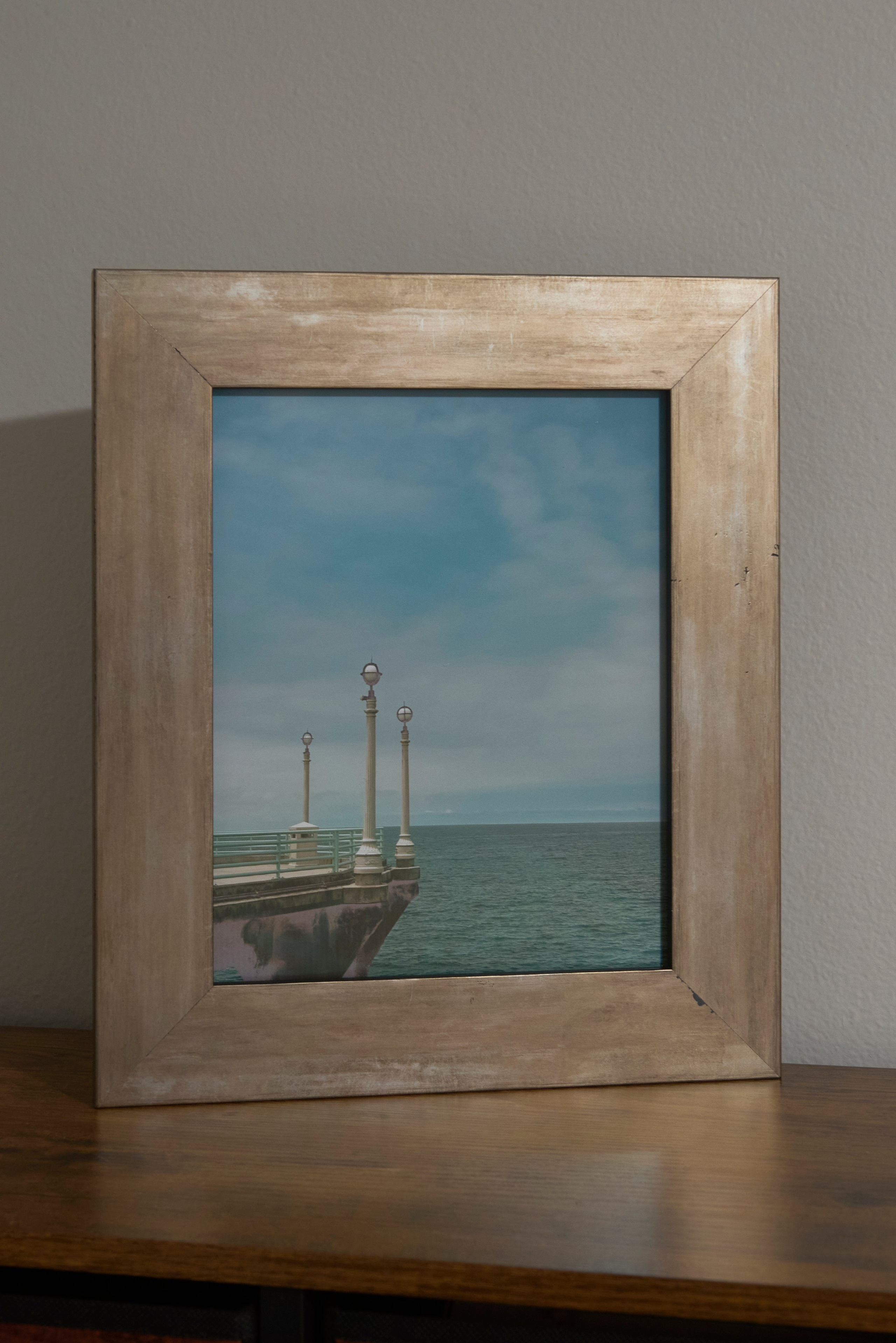 Classic pier lamps extending toward the horizon at Manhattan Beach on a clear coastal day.