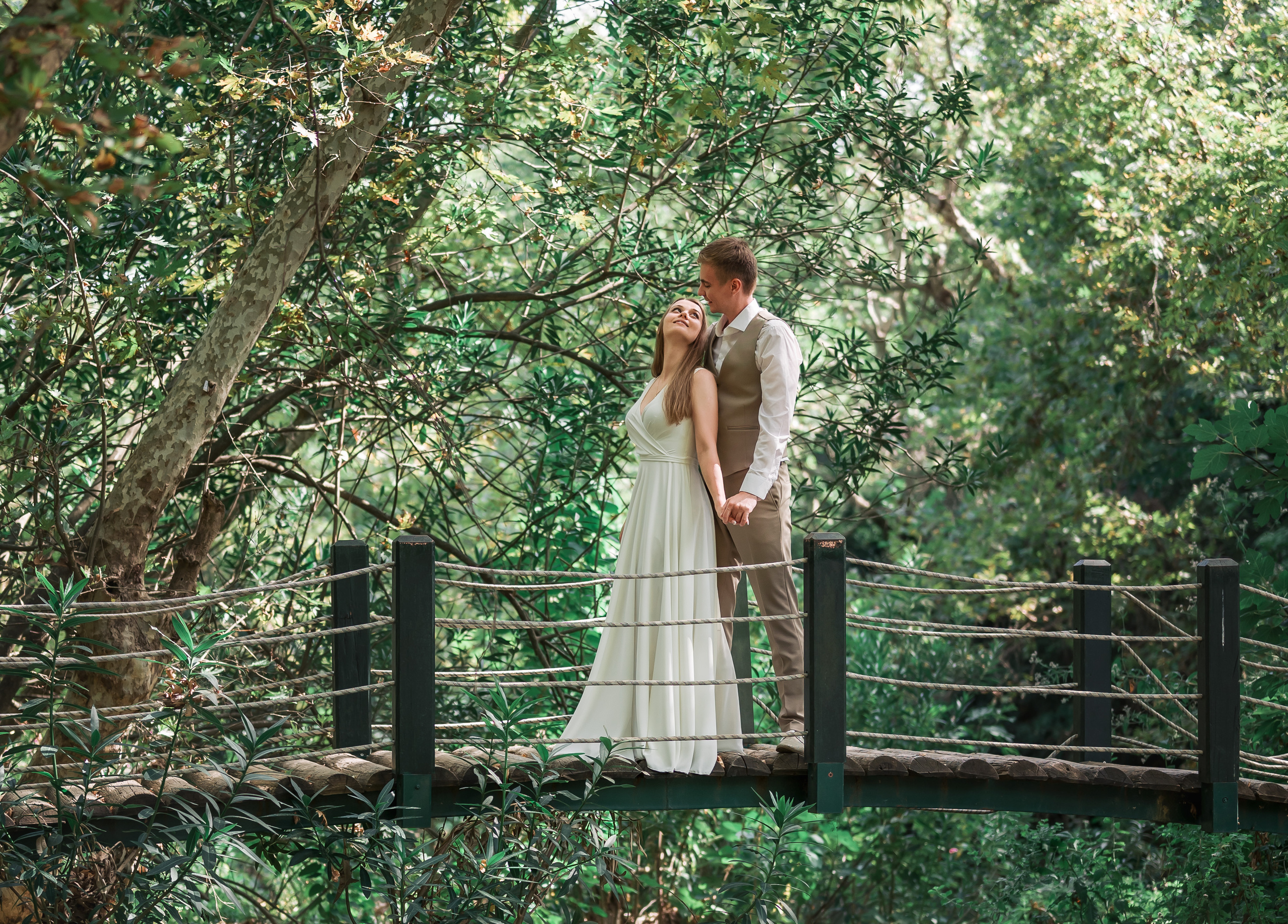 Молодожены на мосту через реку