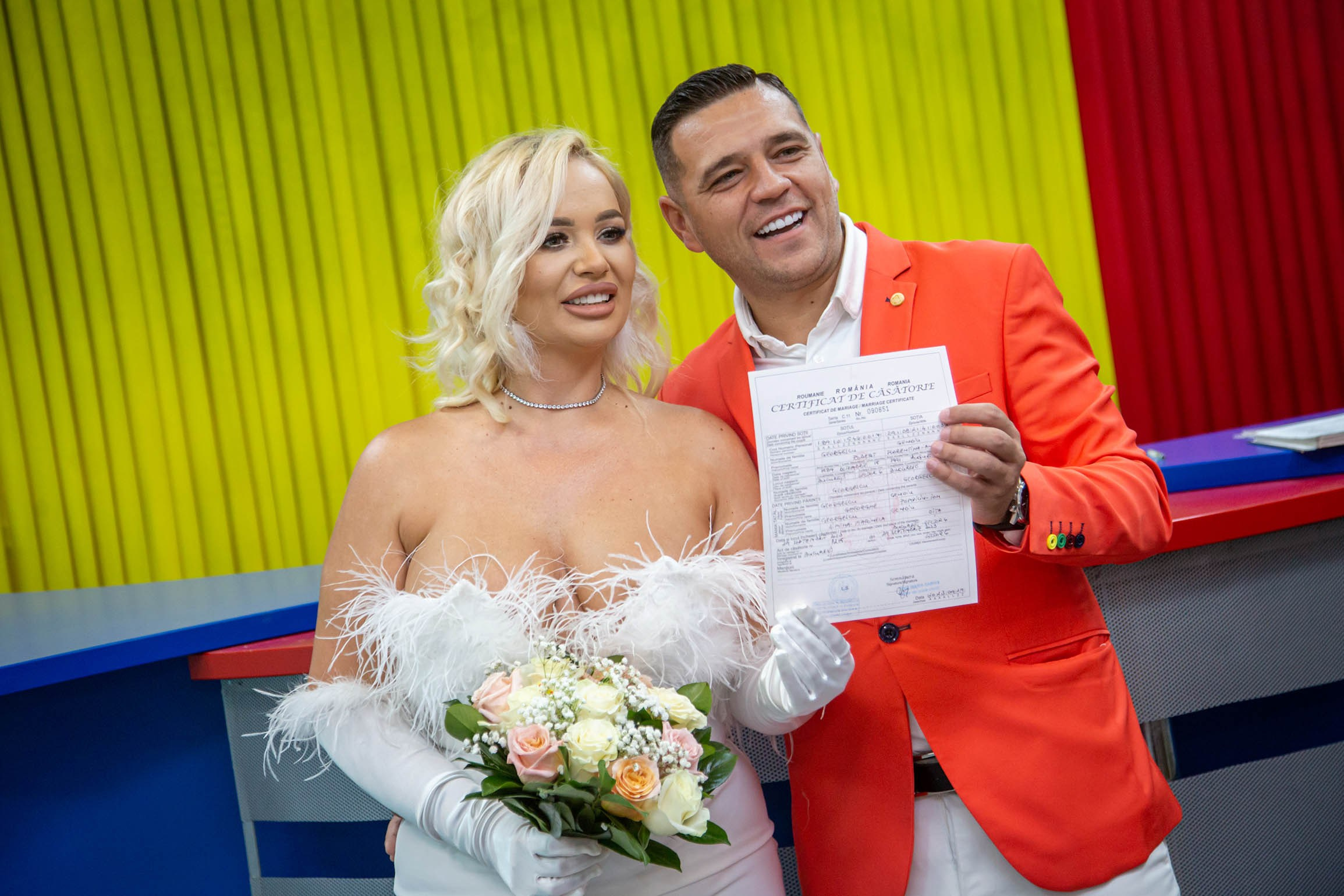 Moment autentic din timpul cununiei civile,mirii pozează cu certificatul de căsătorie