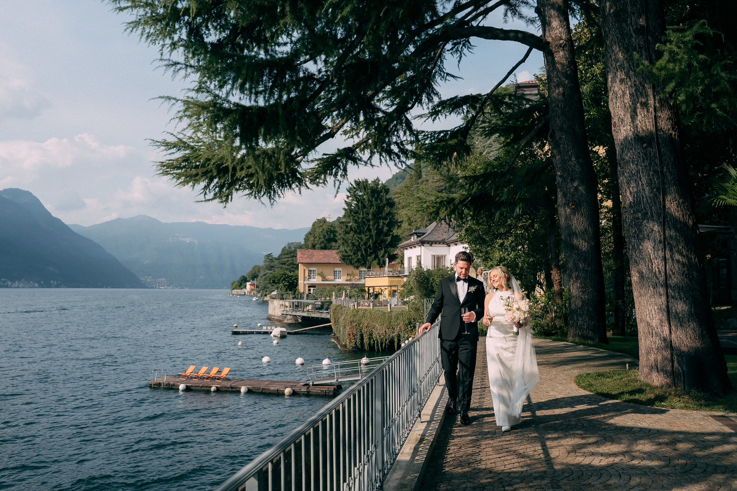 Couple walking along the Lake Como shoreline at Villa Lario, Italy
