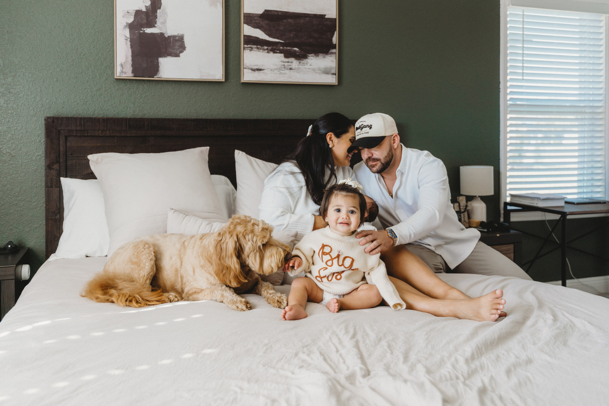 Family sitting on the bed with the dog