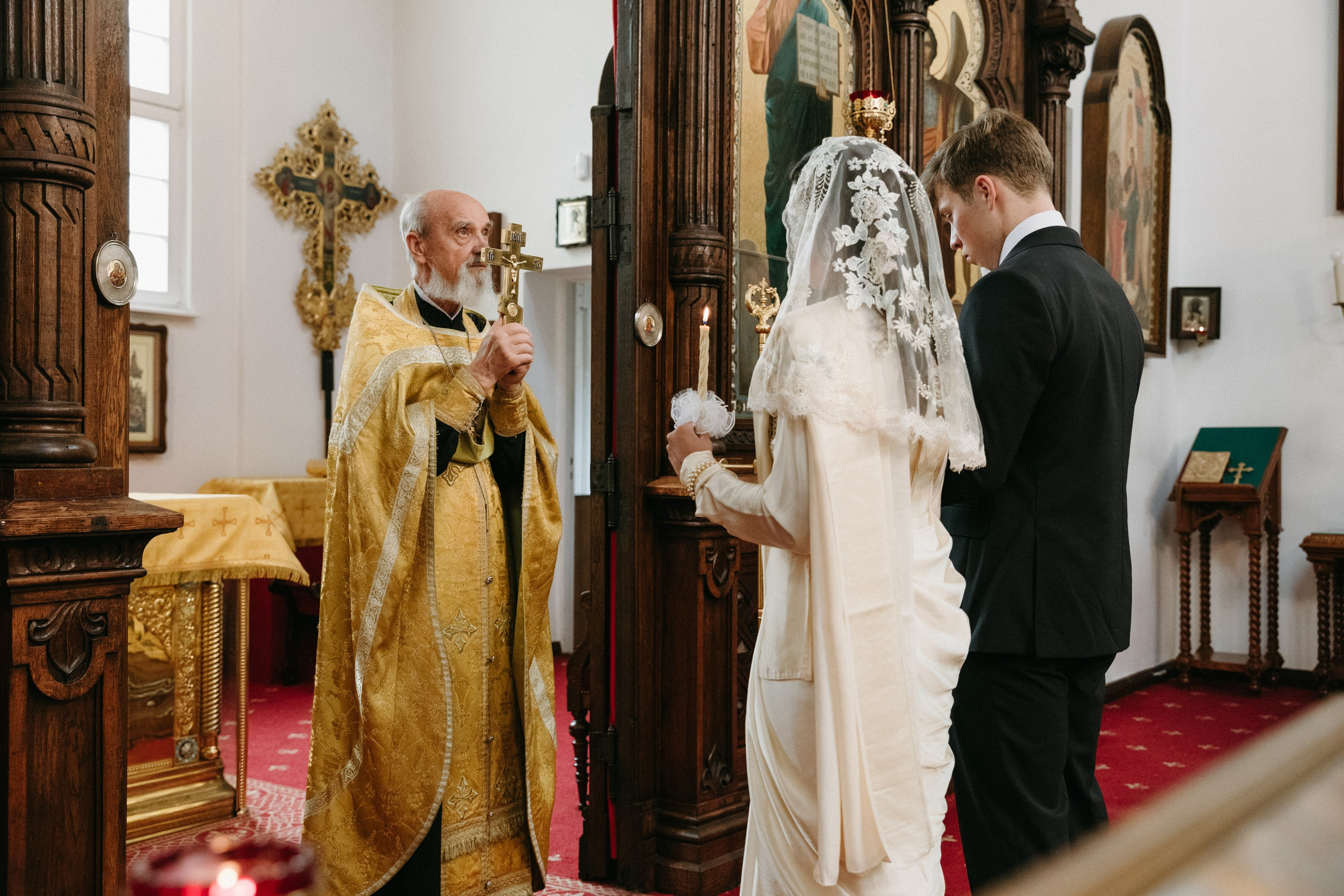 Orthodoxer Priester segnet das Paar mit dem Kreuz während der Trauung