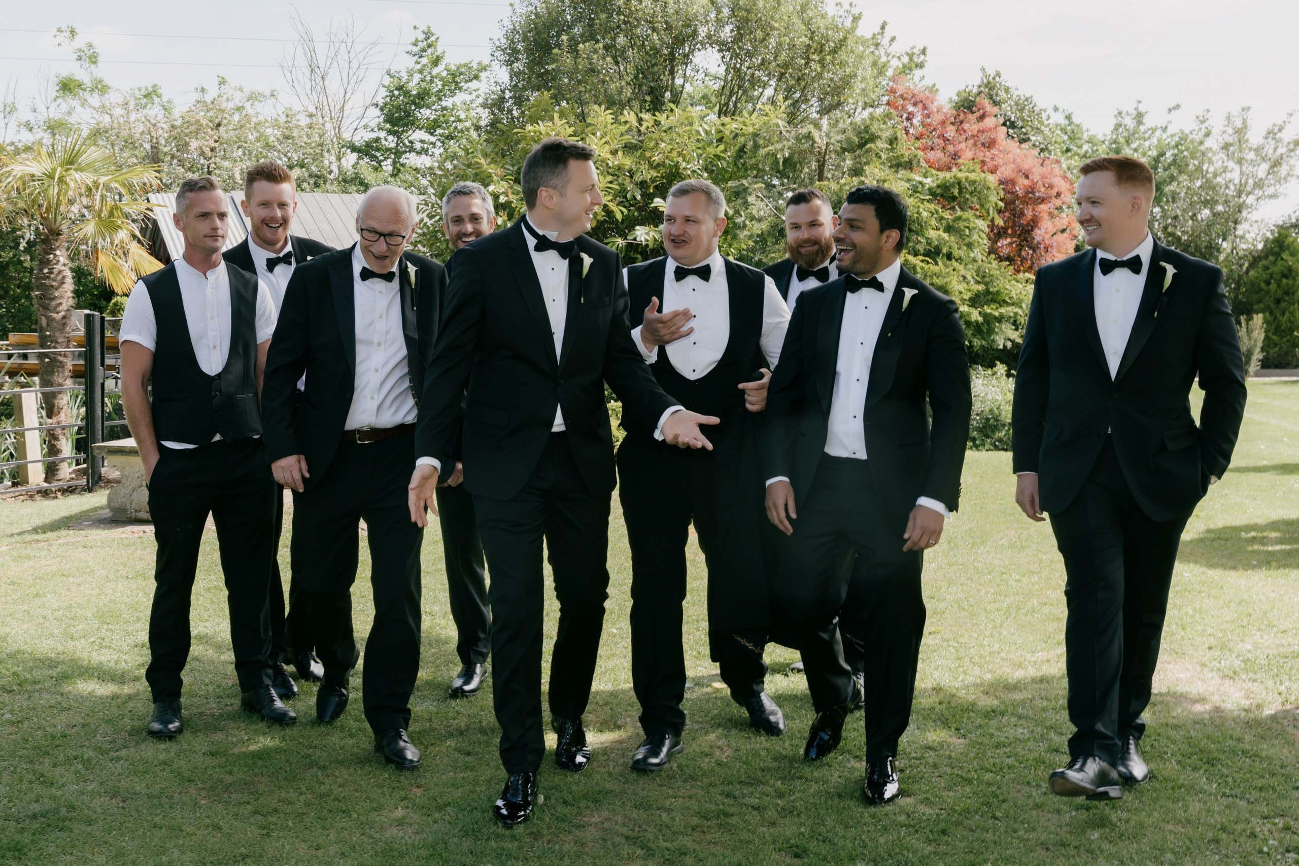 Groom and groomsmen walking together outdoor wedding moment Essex