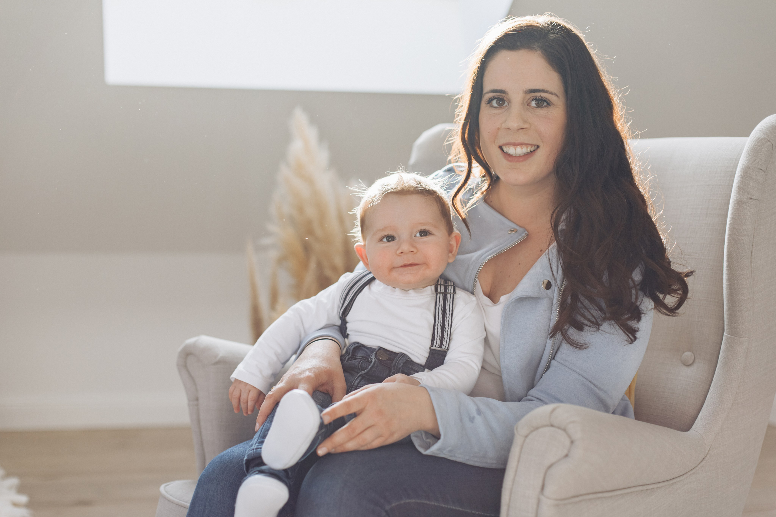 Junge sitzt auf dem Schoß seiner Mutter im Fotostudio.