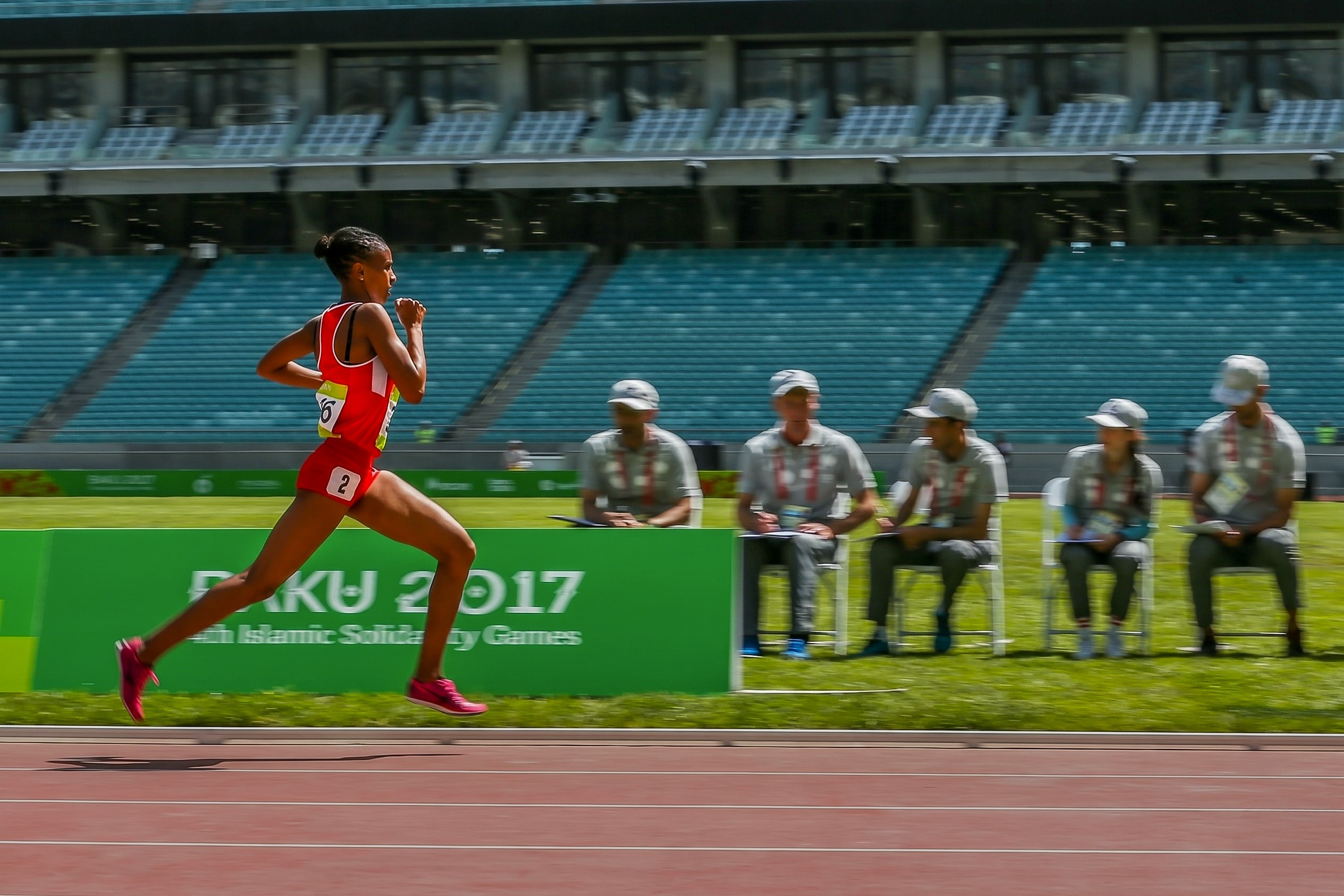 Atletika yarışında qaçış zolağında mübarizə aparan qadın atlet.  Bakı 2017 İslam Həmrəyliyi Oyunları.