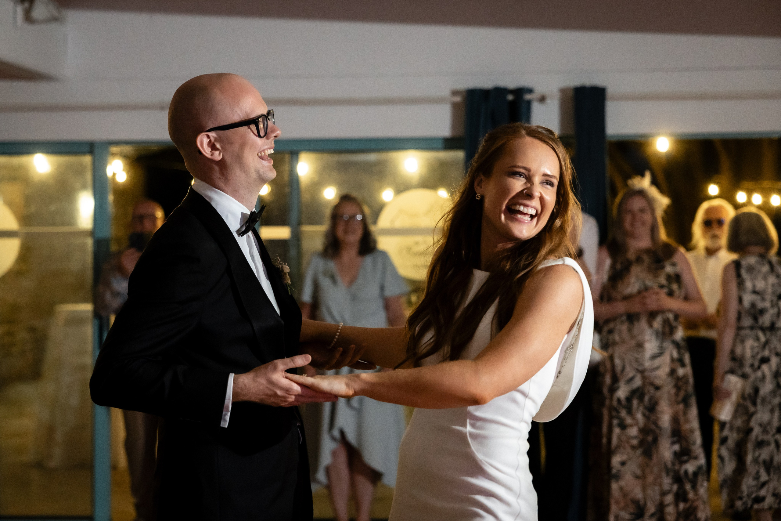 Bride and groom dancing in the evening with their guests around them