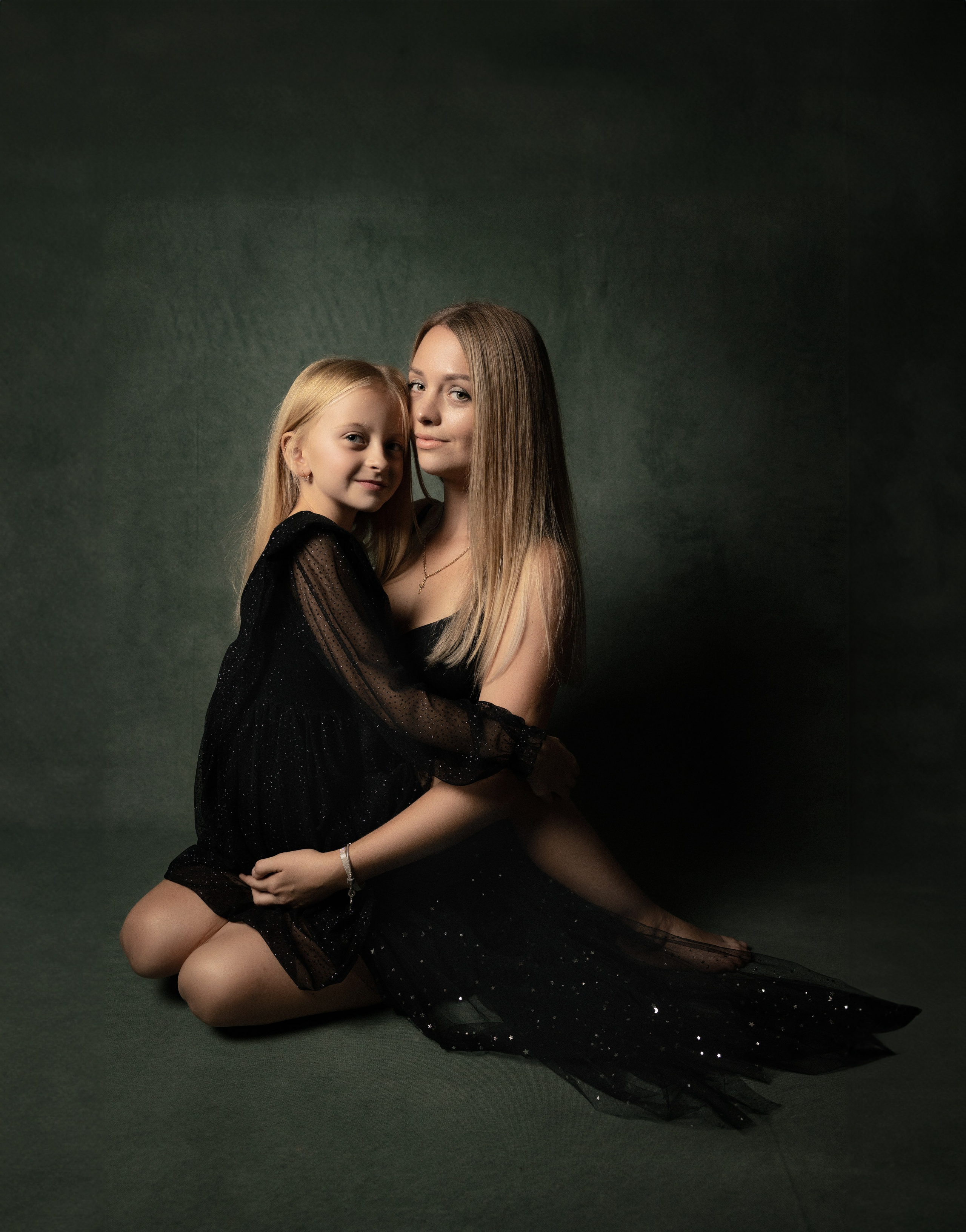 Mama und Tochter in schwarzer Kleidung vor dunklem Hintergrund – stilvolles Fine-Art-Familienfotoshooting in Salzburg.