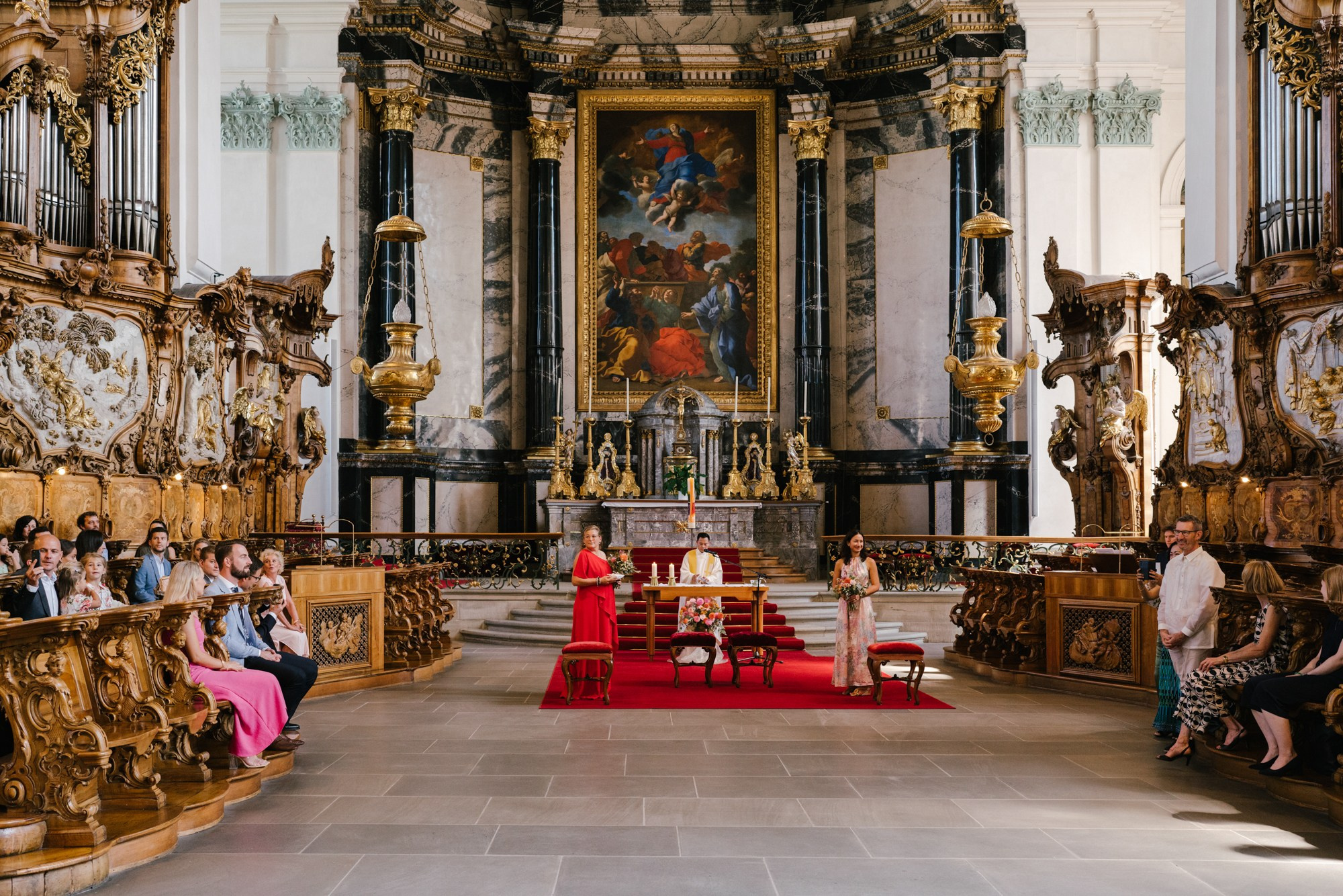 wedding ceremony in St. Gallen Cathedral in Switzerland, people are sitting from the back 