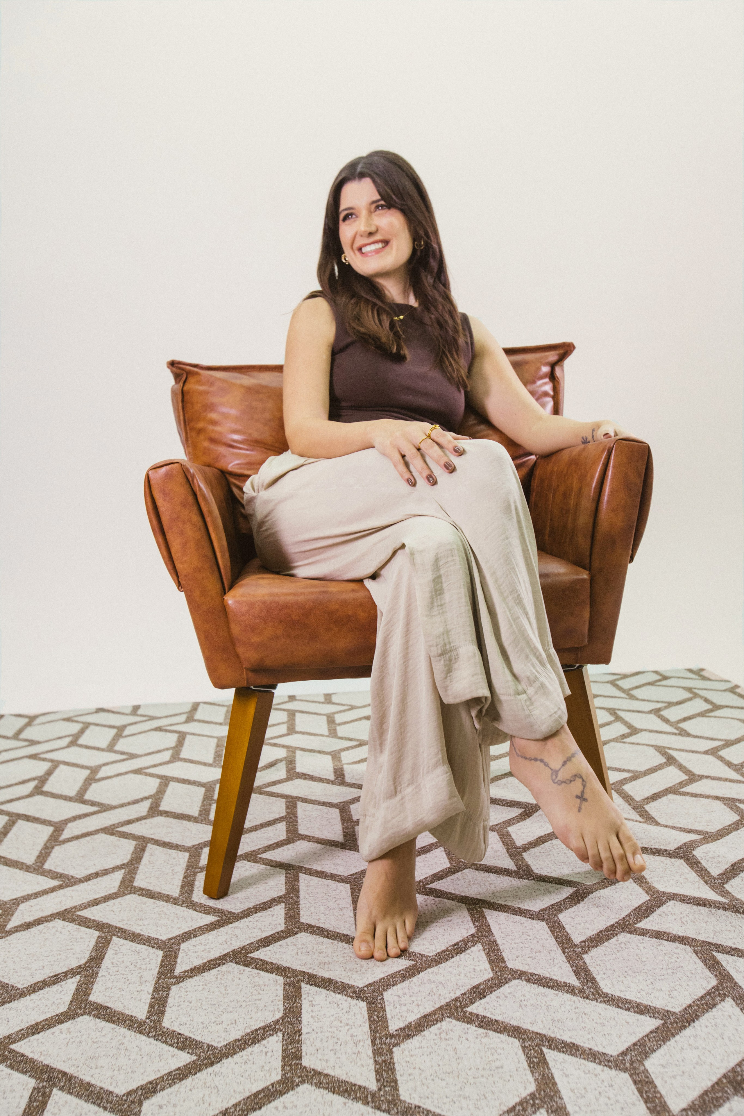 Foto de retrato corporativo de uma psicóloga sentada, feito em estúdio na Palhoça-SC