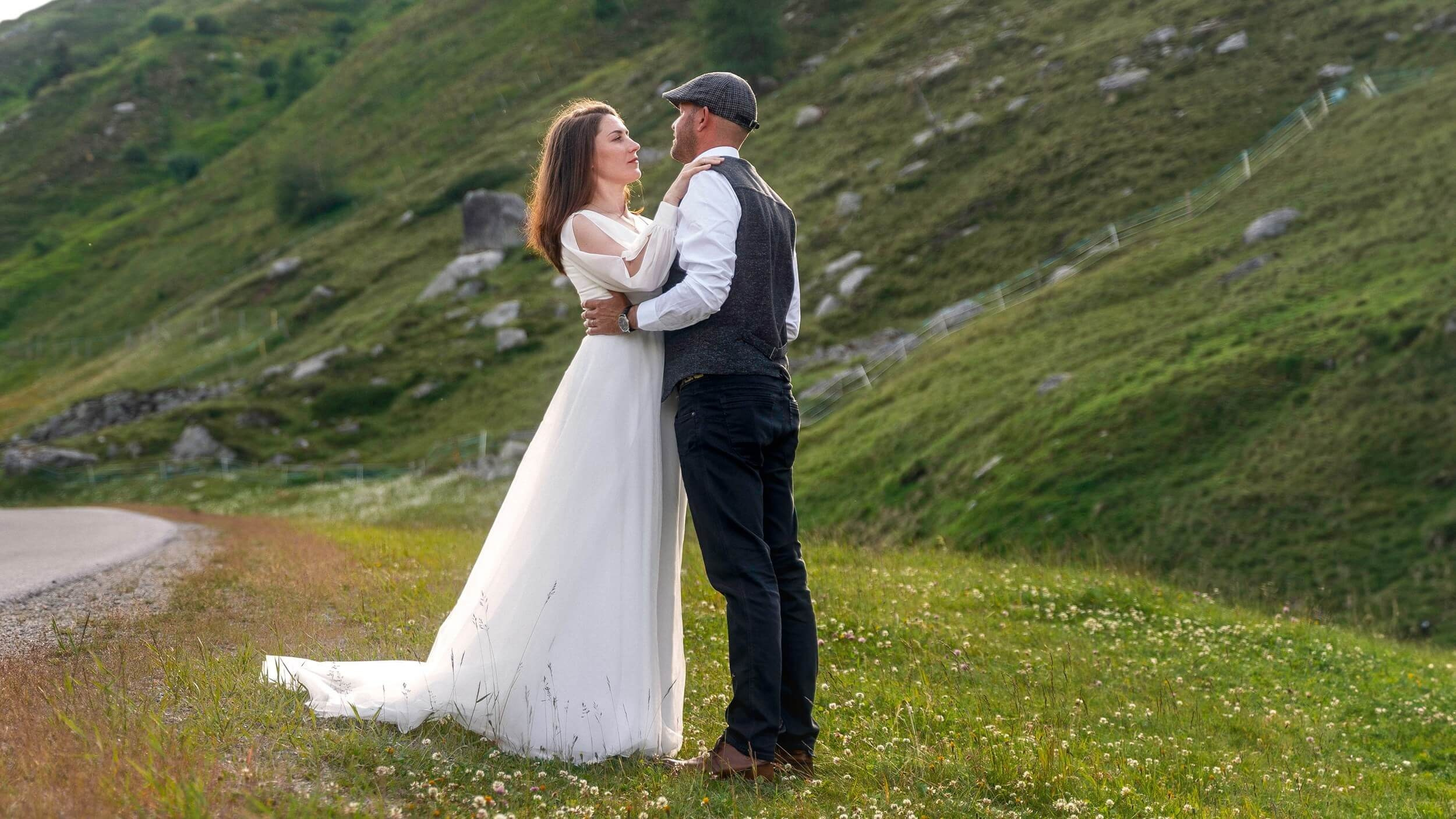Braut und Bräutigam umarmen sich bei ihrer Hochzeit auf einer Wiese in den Söldener Alpen.