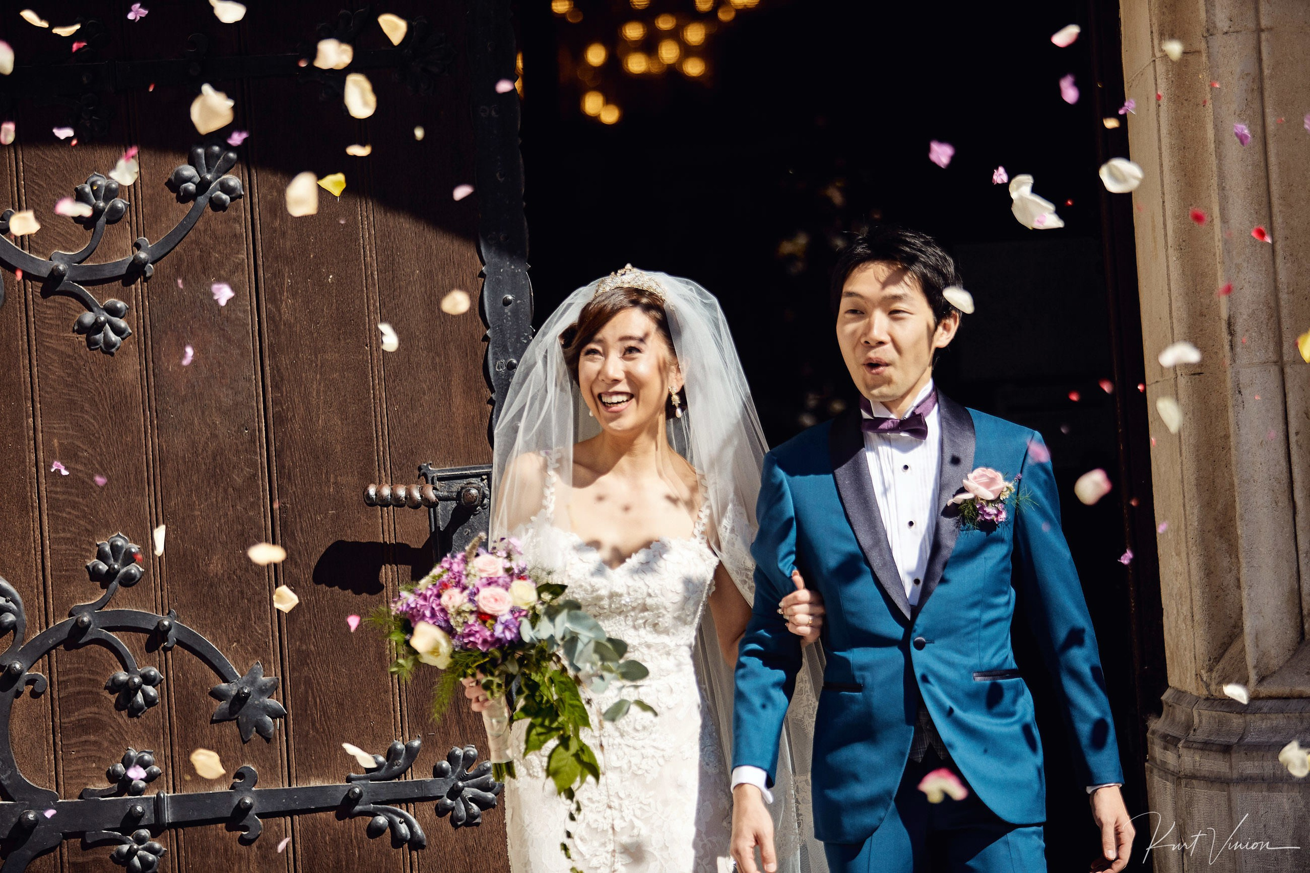 Newlyweds exiting St Martin's Church amid rice rose petal confetti.