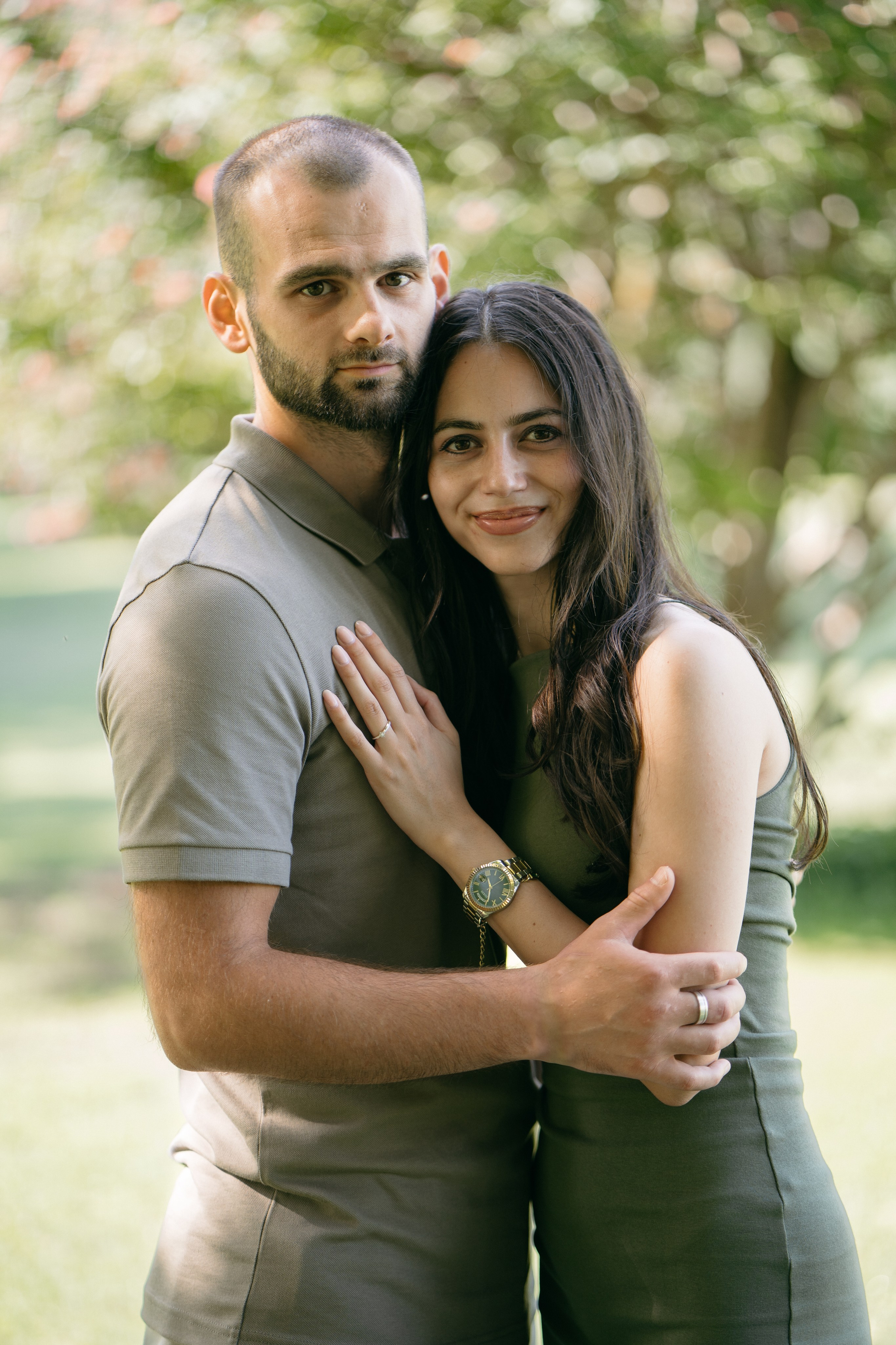 Newly engaged couple embracing among the trees and greenery of Parco Giardino Sigurtà.