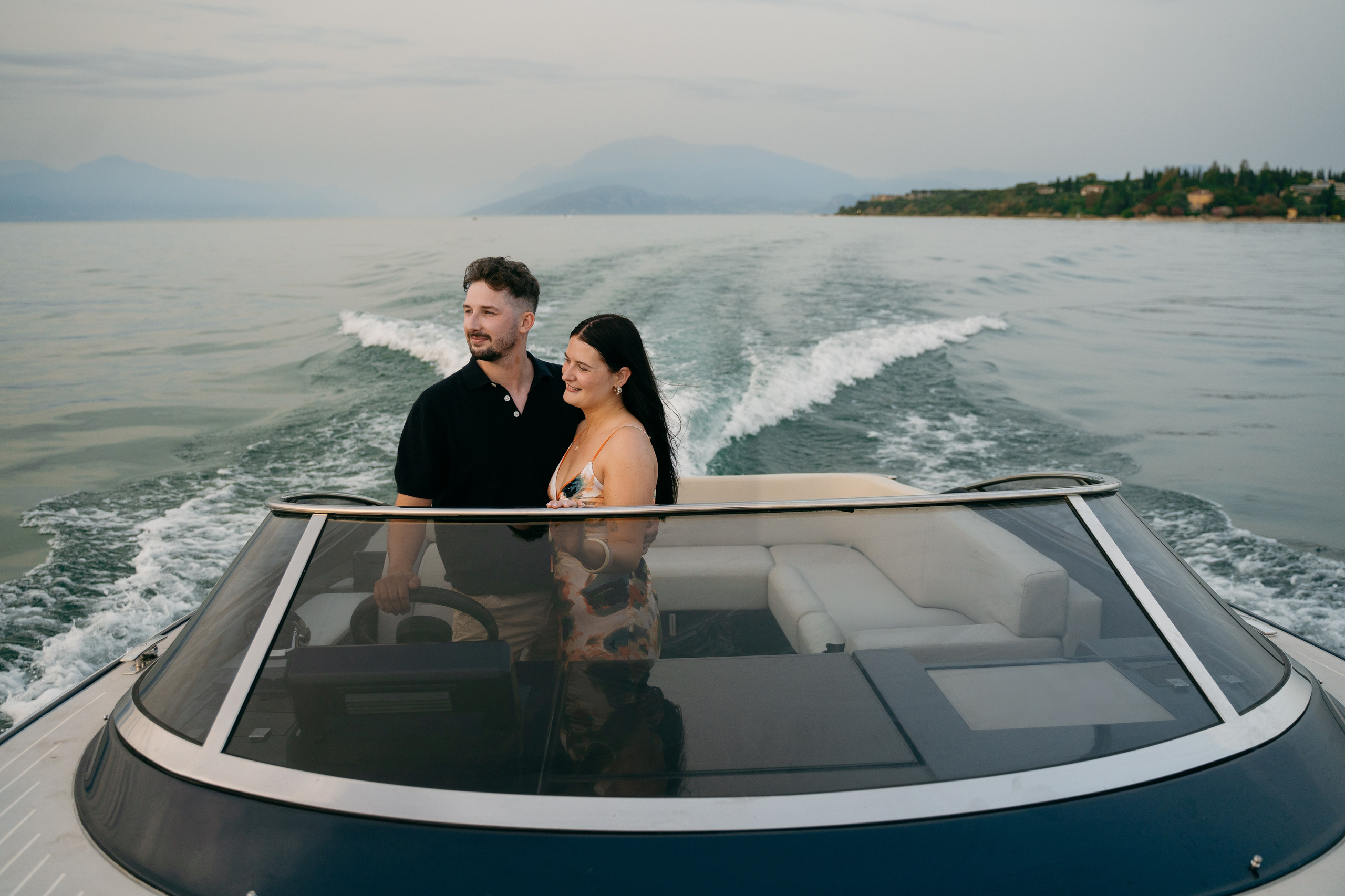 Couple cruising across Lake Garda aboard an elegant private boat near the Sirmione peninsula