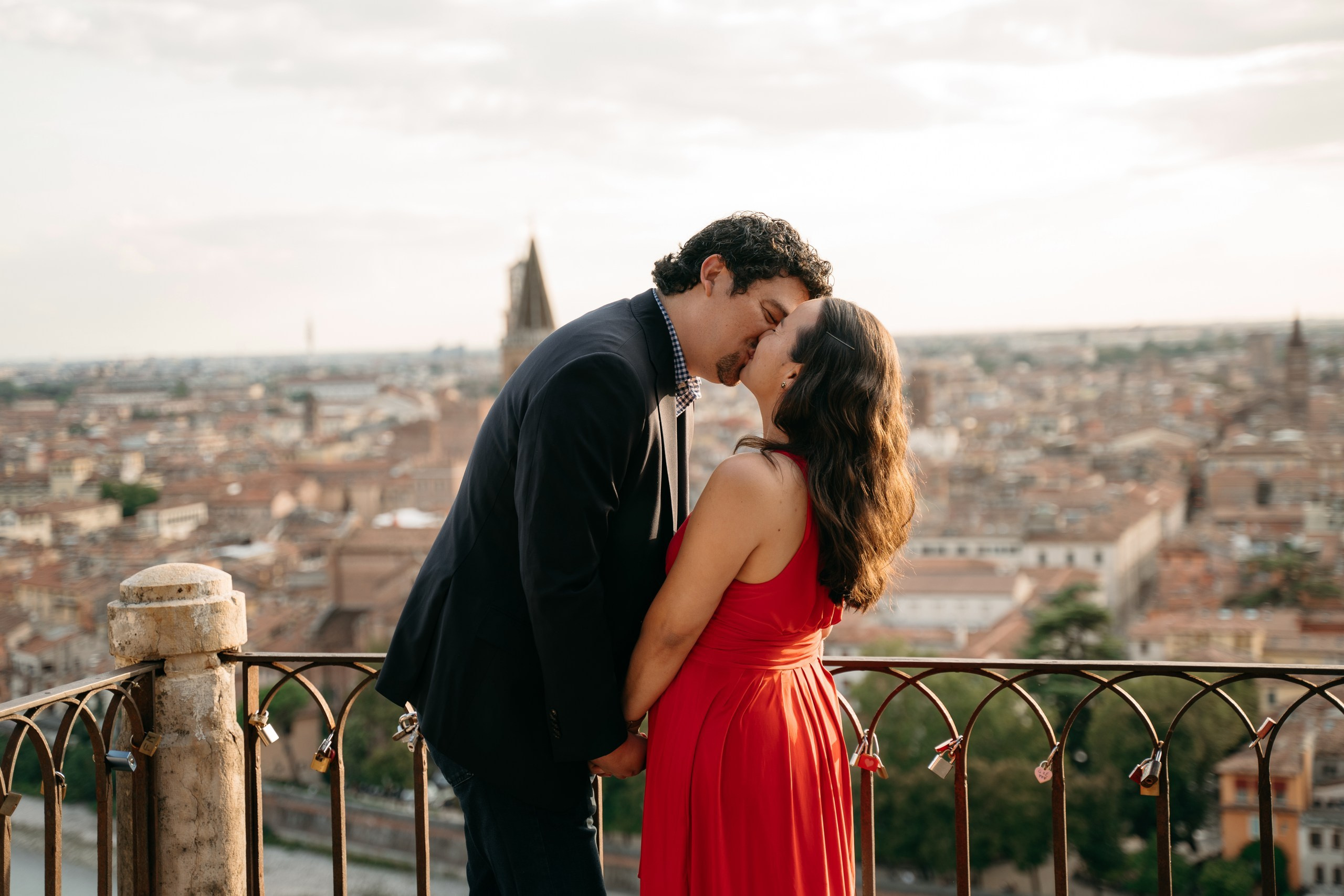 A couple kissing after their proposal at Castel San Pietro in Verona.