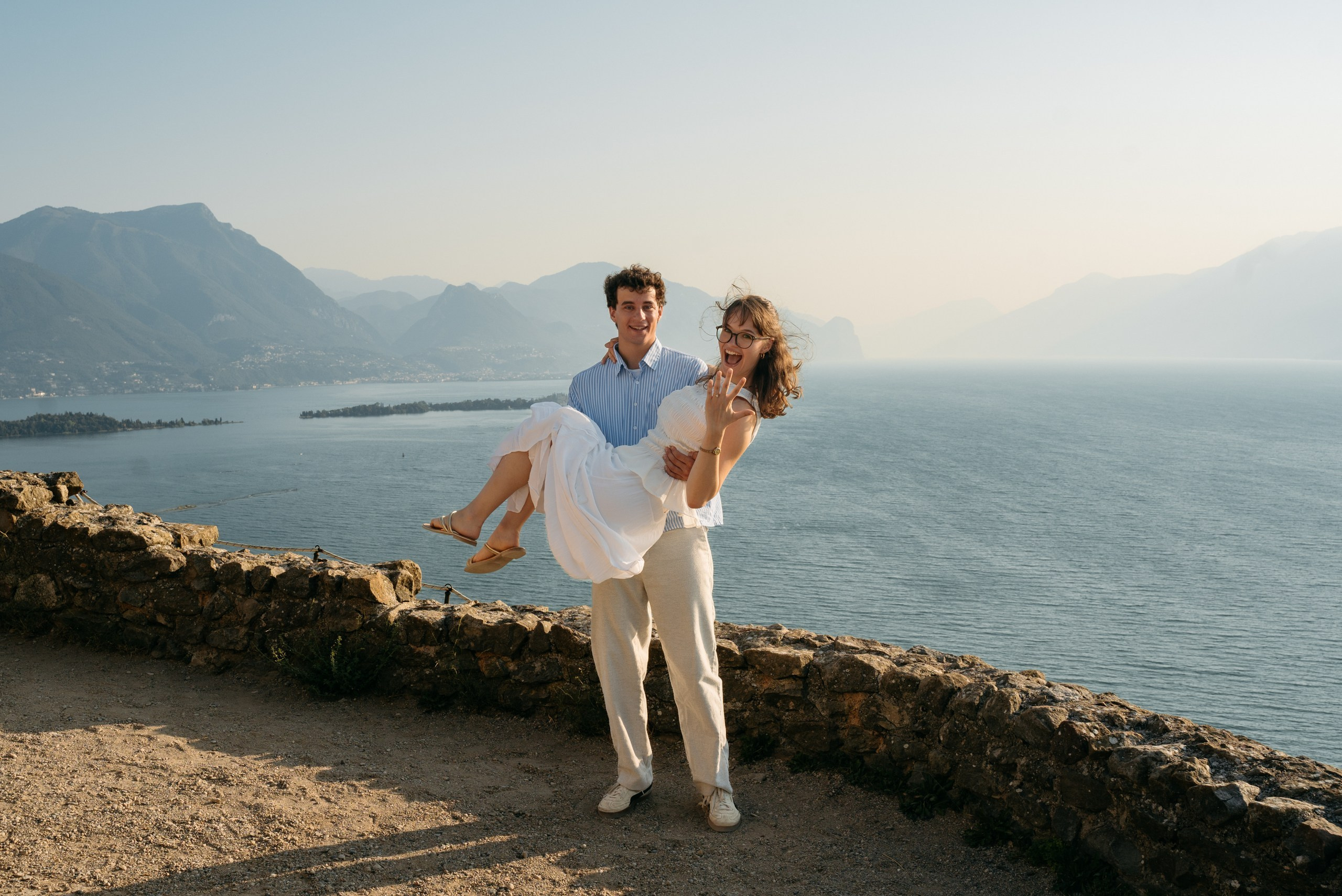 A young couple laughing together during their engagement photoshoot at Rocca di Manerba.