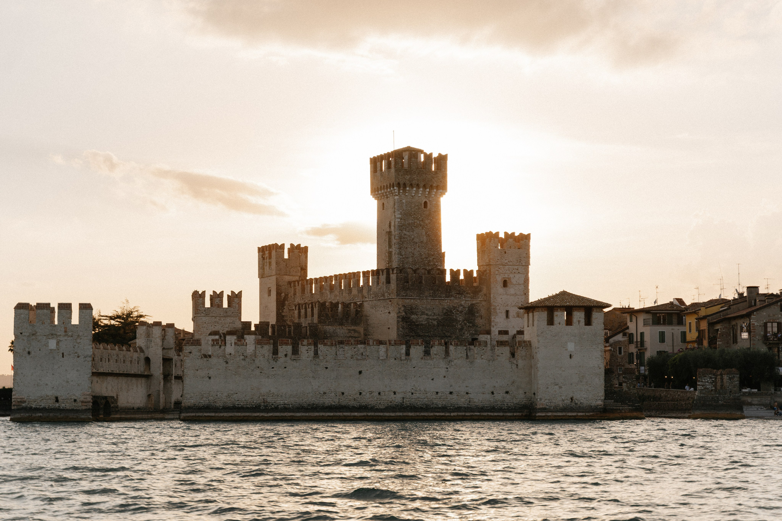 Destination marriage proposal in Sirmione featuring a luxury boat, Lake Garda and the Scaligero Castle.