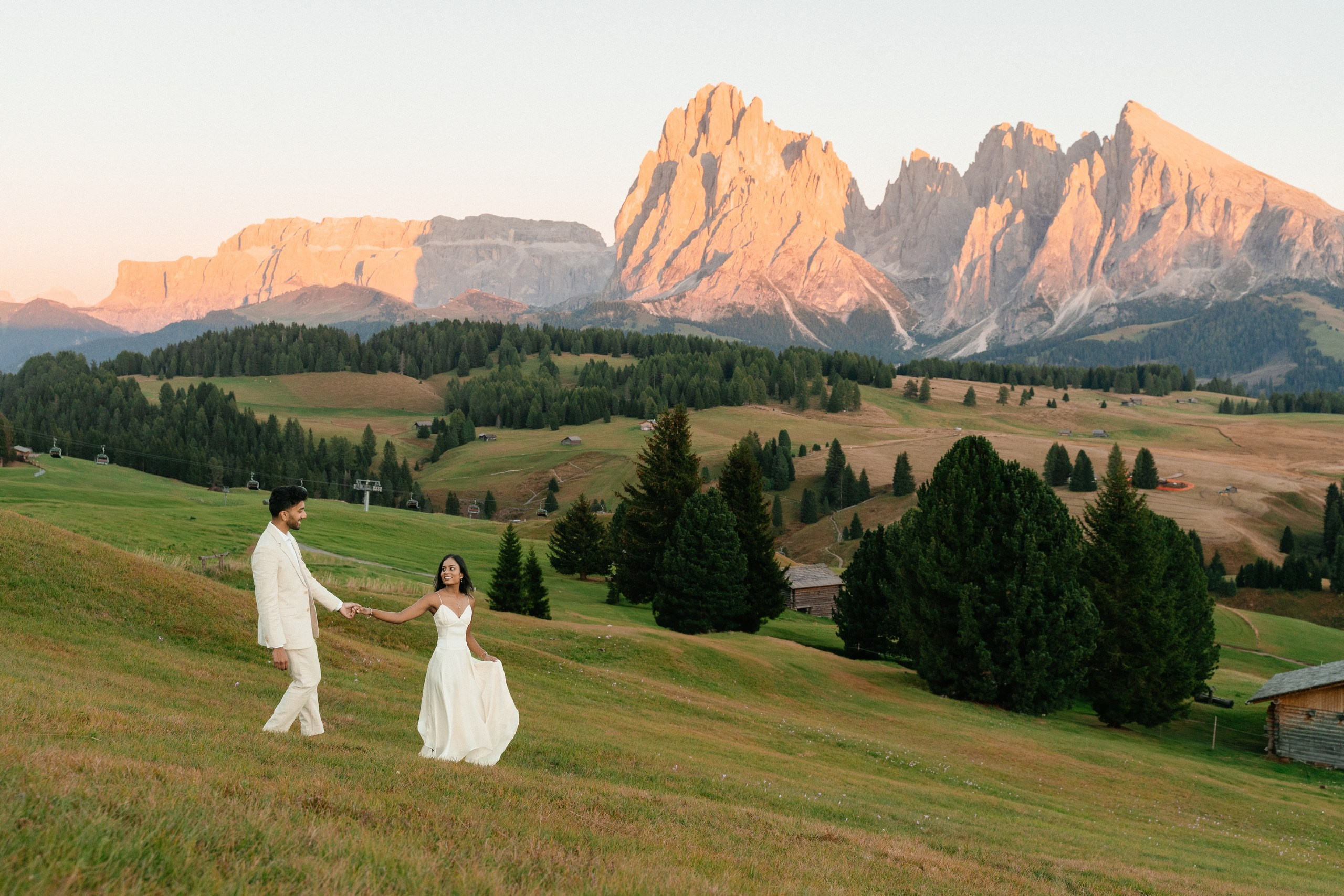 A couple walking together through the landscape near Alpe Lodge in Alpe di Siusi