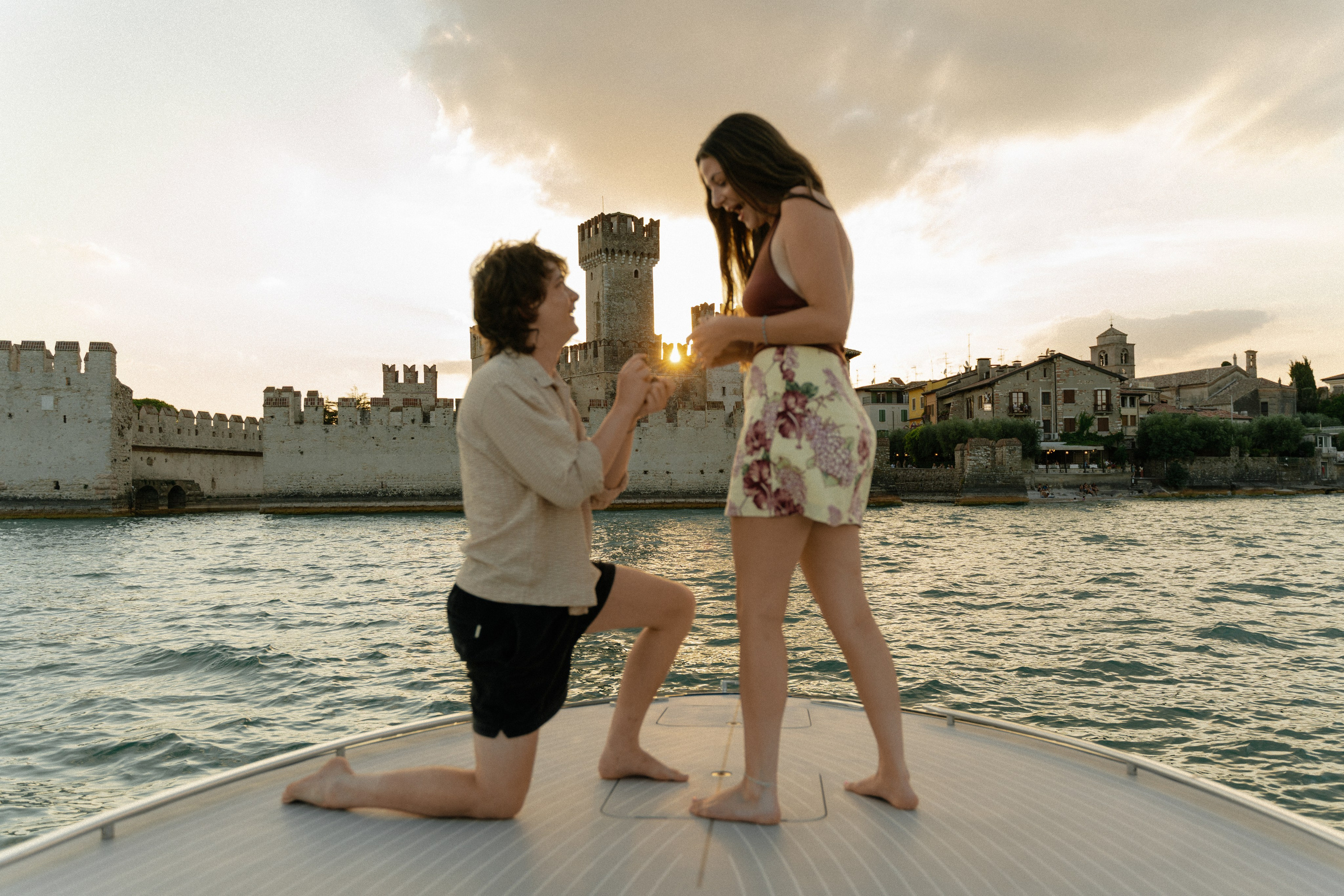 Luxury boat marriage proposal at sunset in front of Sirmione Castle on Lake Garda, Italy