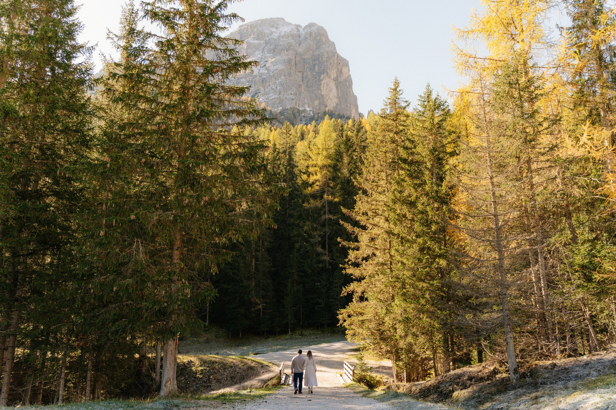 Couple surrounded by autumn foliage during a photoshoot in Alta Badia, South Tyrol.
