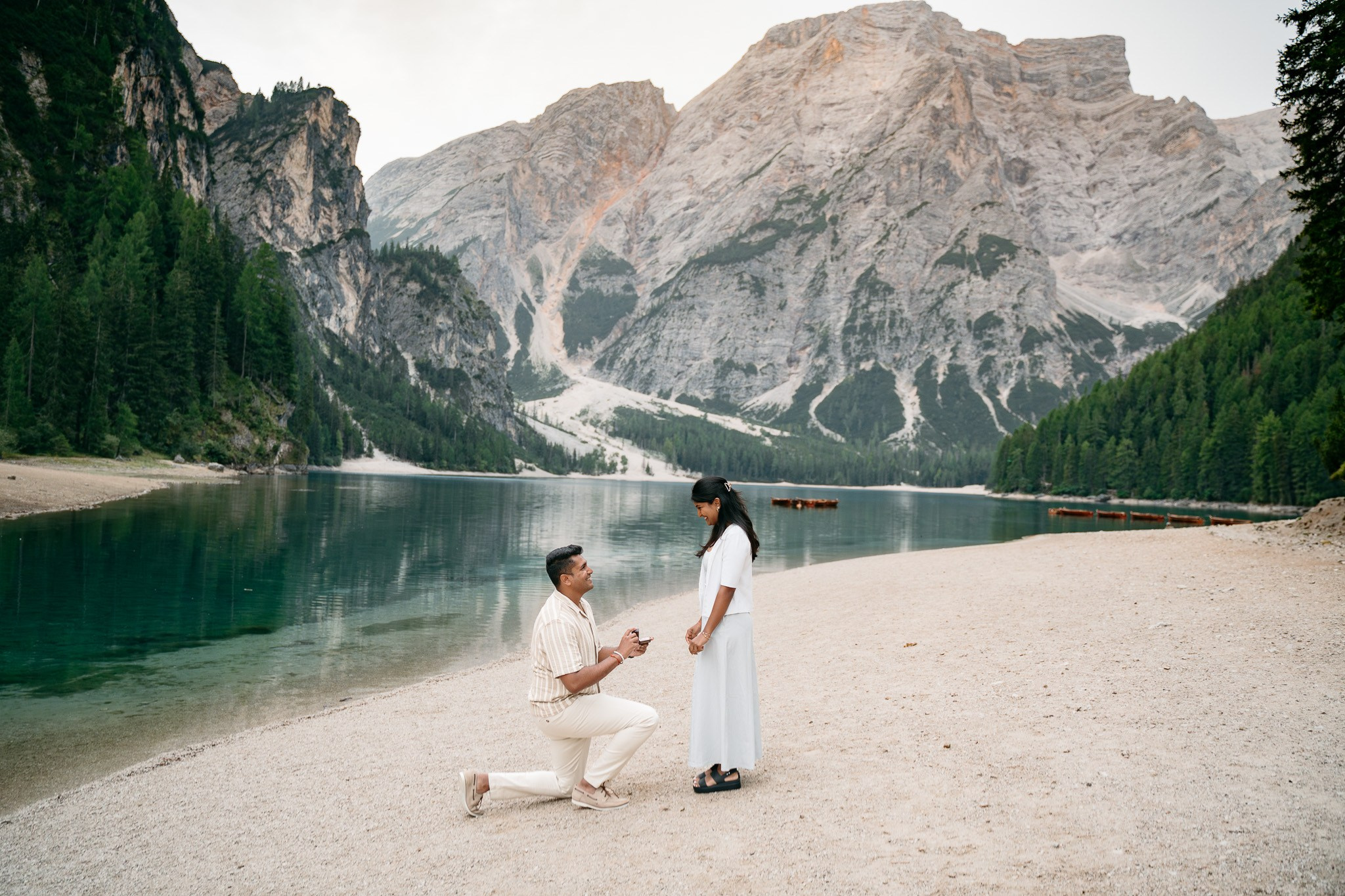 Sunrise marriage proposal on the shore of Lago di Braies in the Italian Dolomites.