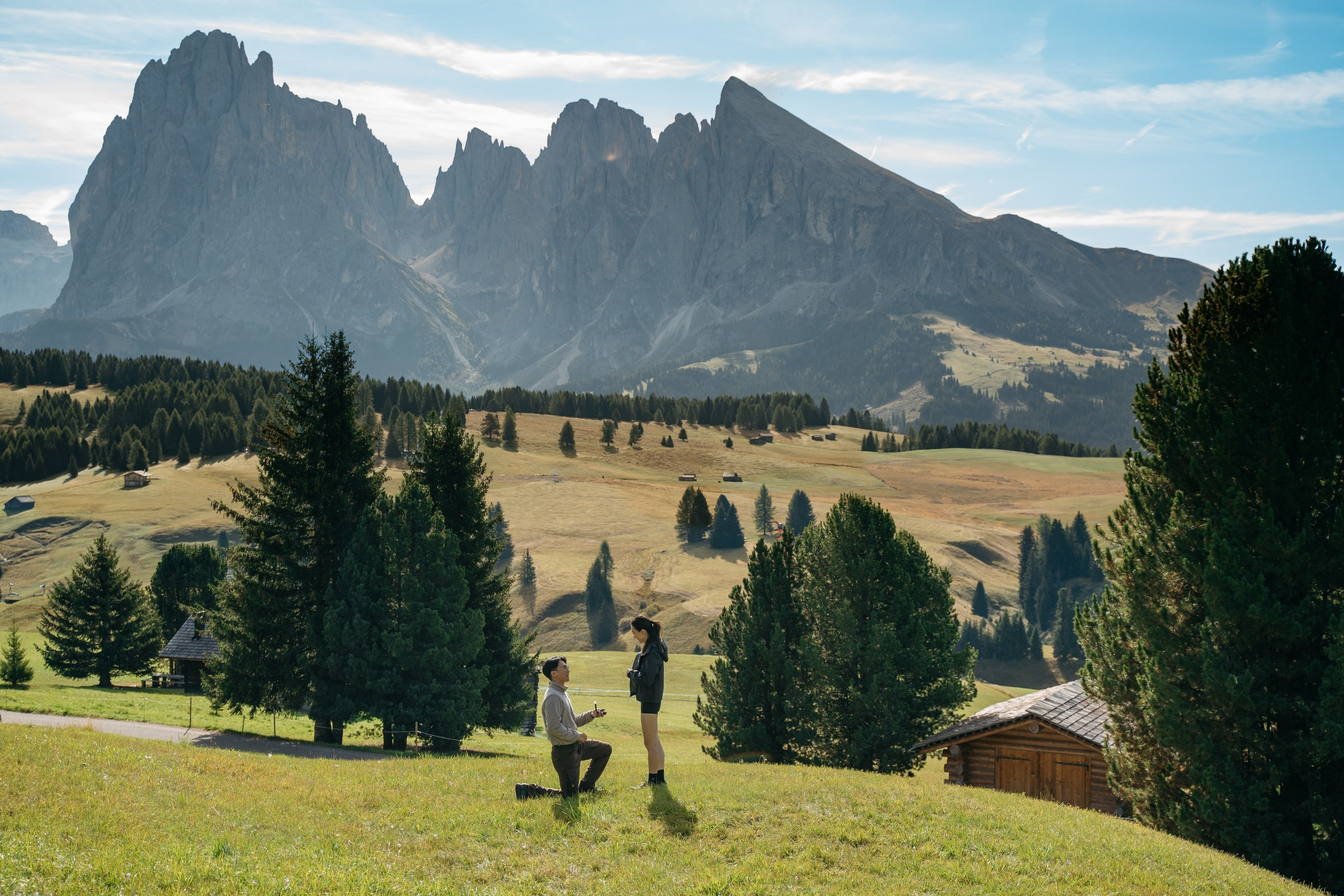 An Asian couple during their morning marriage proposal on Alpe di Siusi, surrounded by the Dolomites.