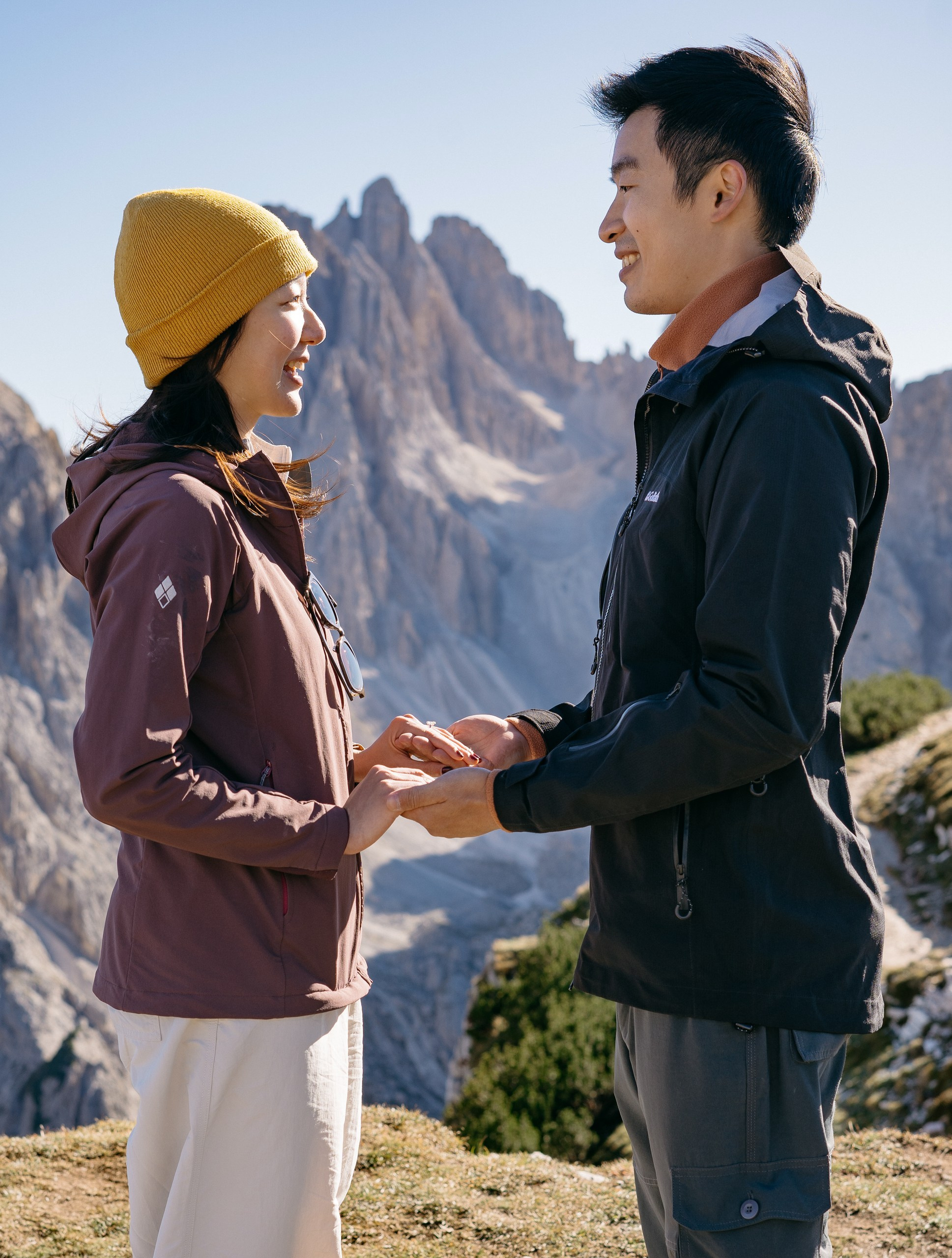 An Asian couple standing together at a panoramic viewpoint during their Cadini di Misurina engagement photoshoot.