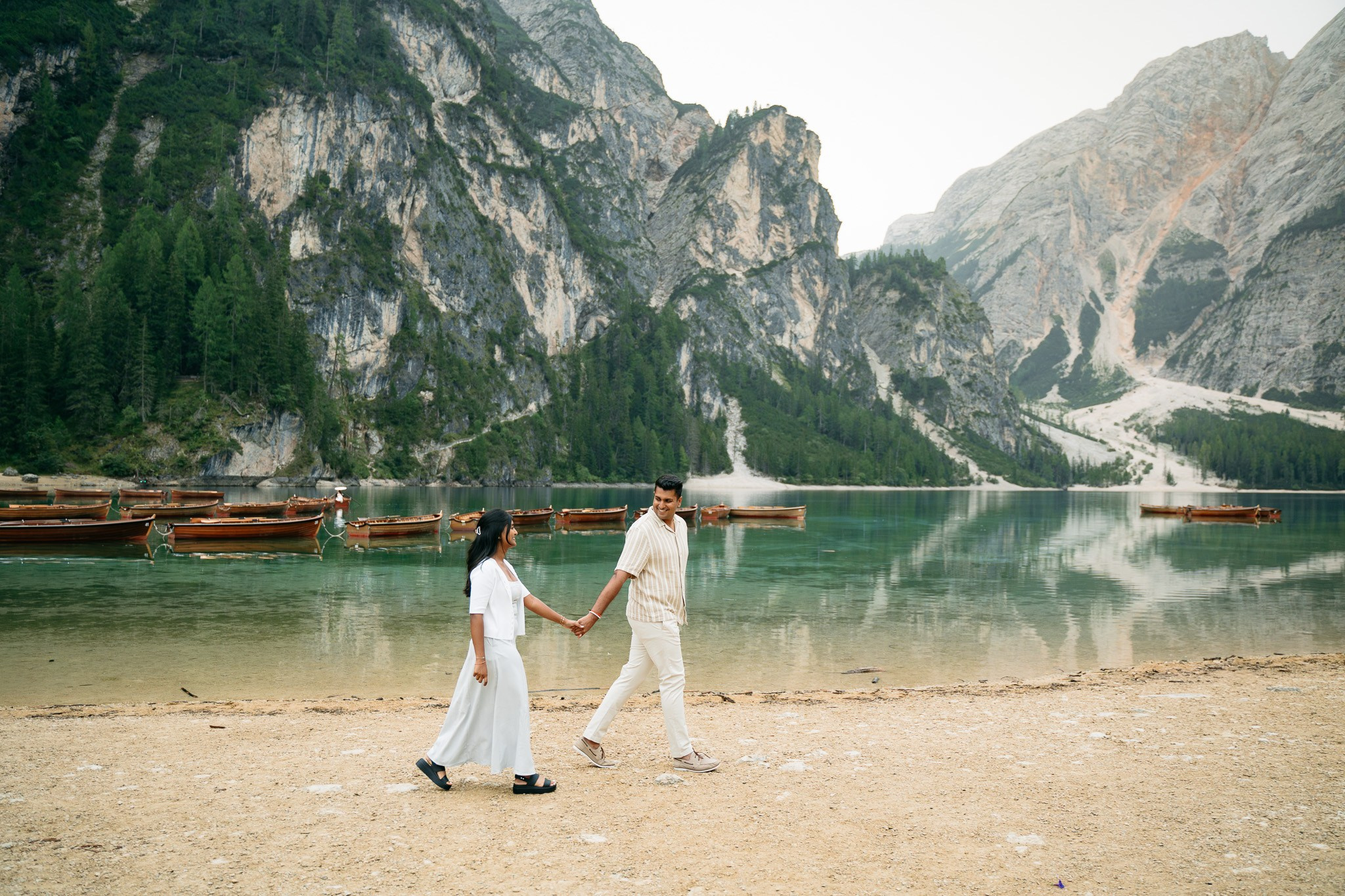 Romantic proposal photography at Lago di Braies with the mountains reflected in the lake.